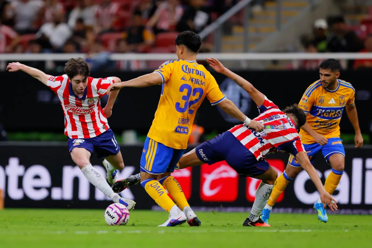 Empate de Guadalajara y Tigres en el Apertura mexicano, con jugadores de ambos equipos disputando el balón durante el encuentro.