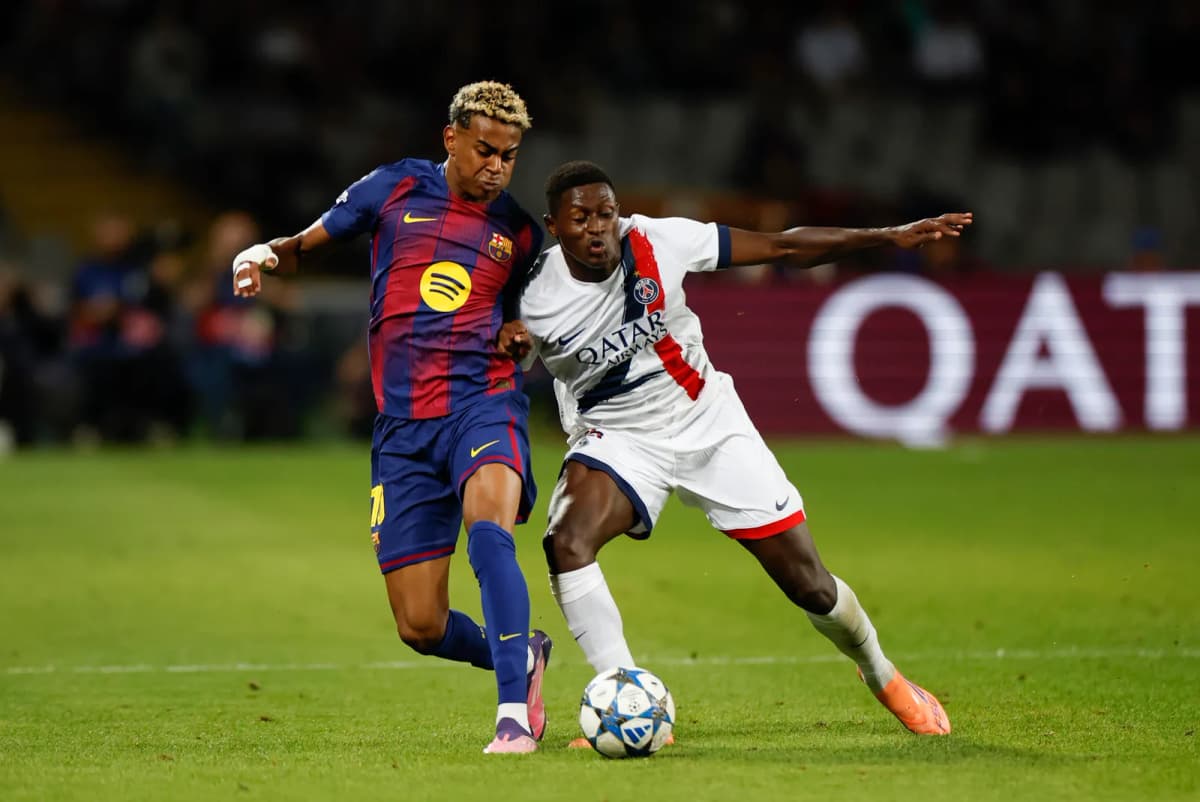 El delantero del FC Barcelona, Lamine Yamal (i), disputa el balón con el defensa portugués del París Saint-Germain Nuno Mendes, durante el partido de la…