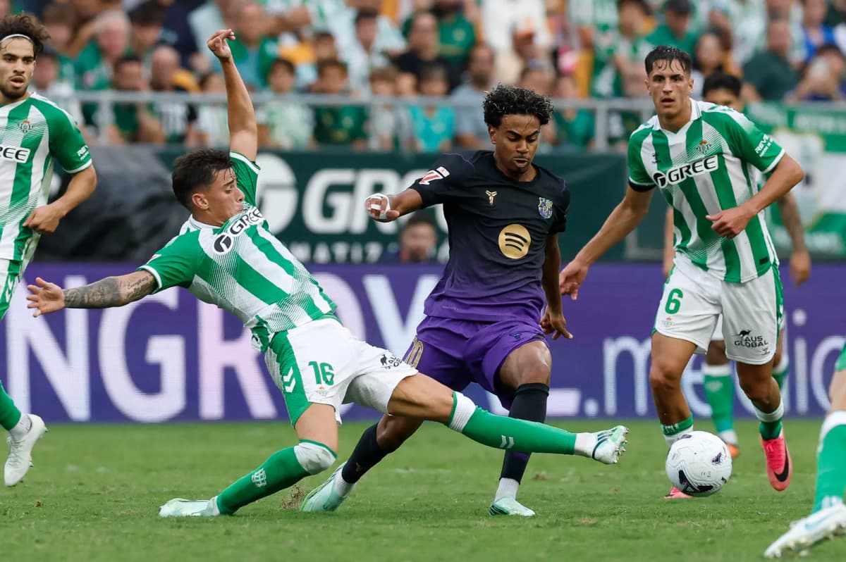 El delantero del Barcelona Lamine Yamal (c) lucha con Valentín Gómez (i), del Betis, durante el partido de la jornada 9 de LaLiga entre Real Betis y FC…