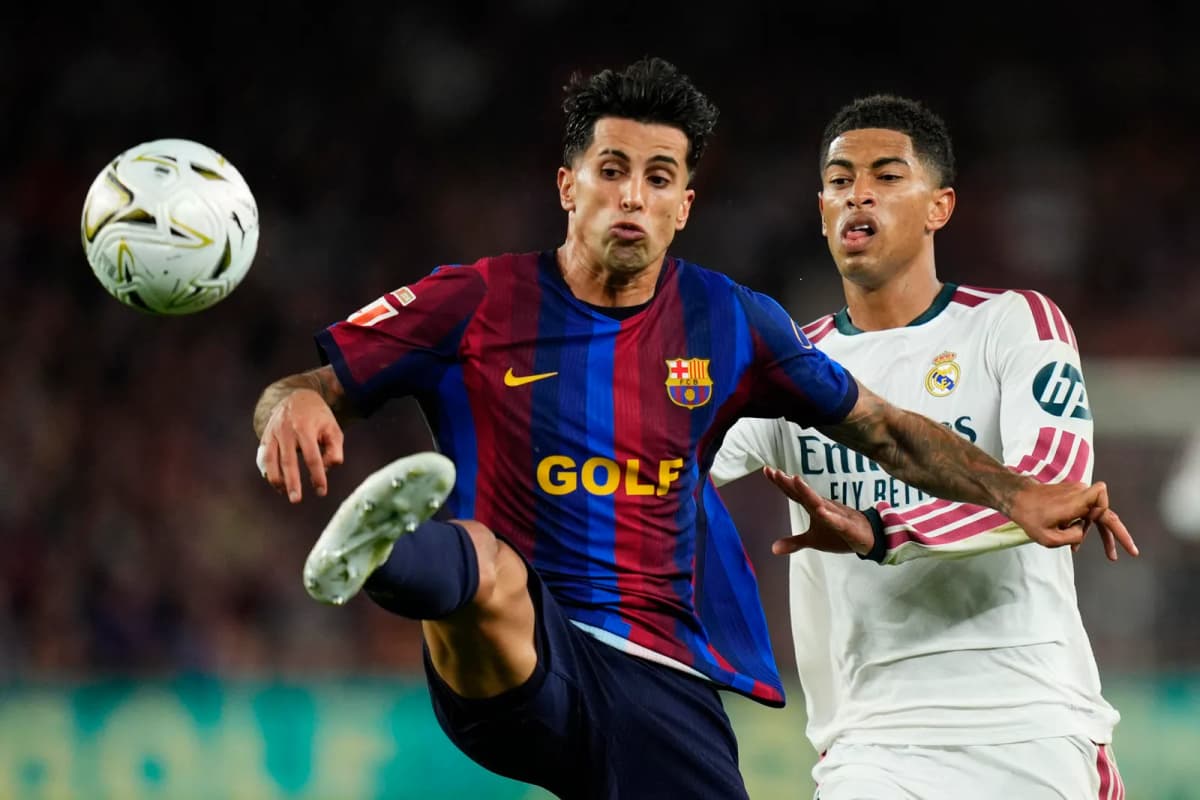 El defensa portugués del FC Barcelona, João Cancelo (i), disputa el balón ante el centrocampista inglés del Real Madrid, Jude Bellingham, durante el encuentro…