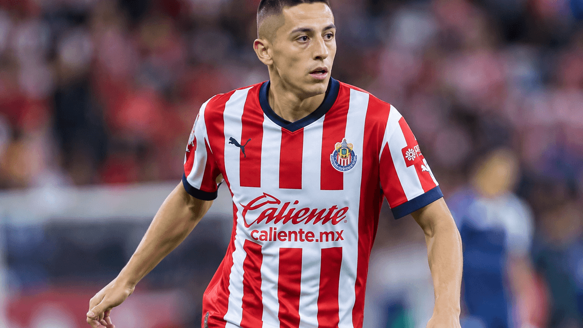 El futbolista mexicano Roberto Alvarado viste la camiseta rojiblanca de Chivas durante un partido disputado en un estadio iluminado.