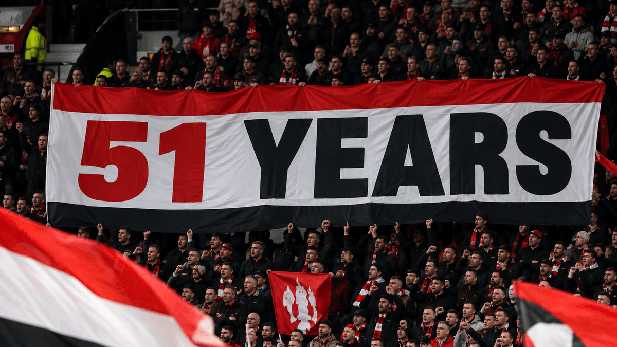 Vista de la grada Stretford End de Old Trafford, con una pancarta alusiva al Manchester City como posible portada.