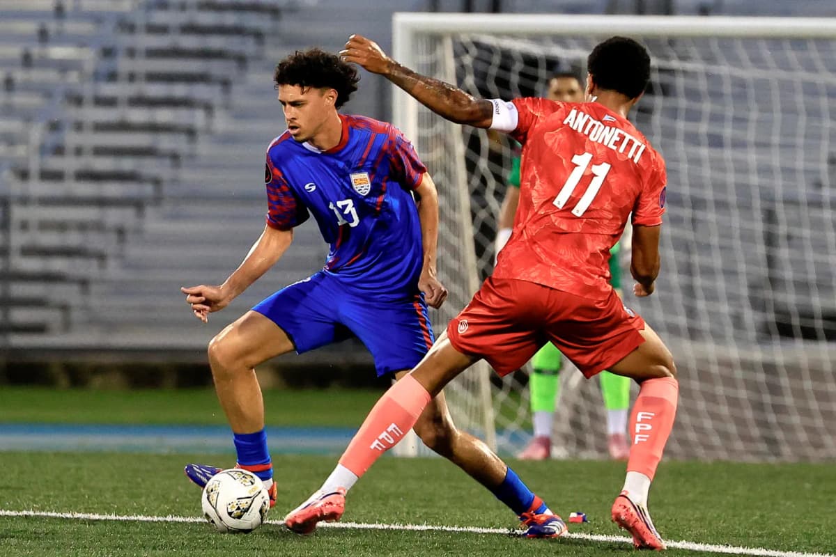 Leandro Antonetti (d) de Puerto Rico disputa un balón con Harrison Hew de las Islas Caimán en un partido de la Liga de Naciones Concacaf.