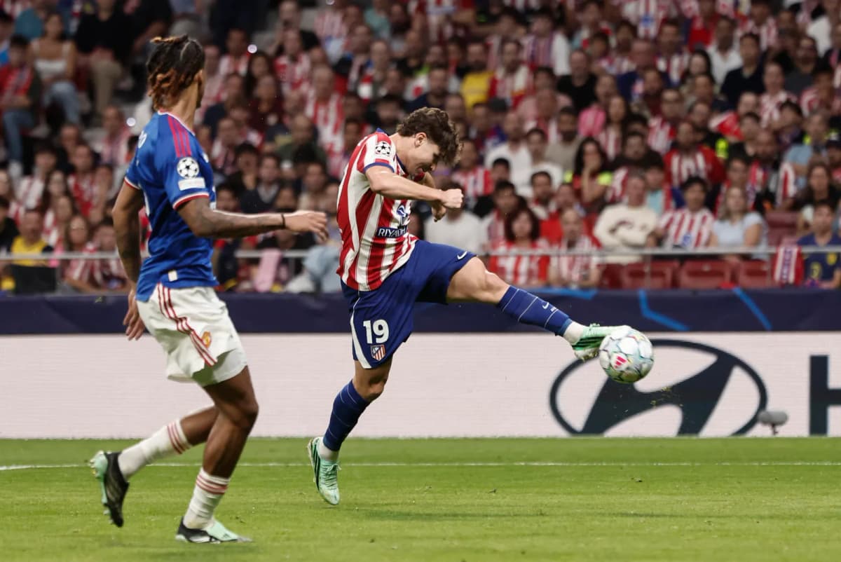El argentino Julián Álvarez, delantero del Atlético de Madrid, remata ante el defensa francés Leny Yoro, del Manchester United.
