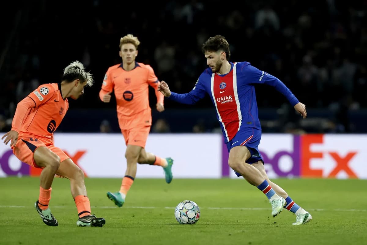 El delantero georgiano del PSG, Khvicha Kvaratskhelia (D), trata de regatear al barcelonista Pedri (I), durante el partido de la Liga de Campeones disputado…