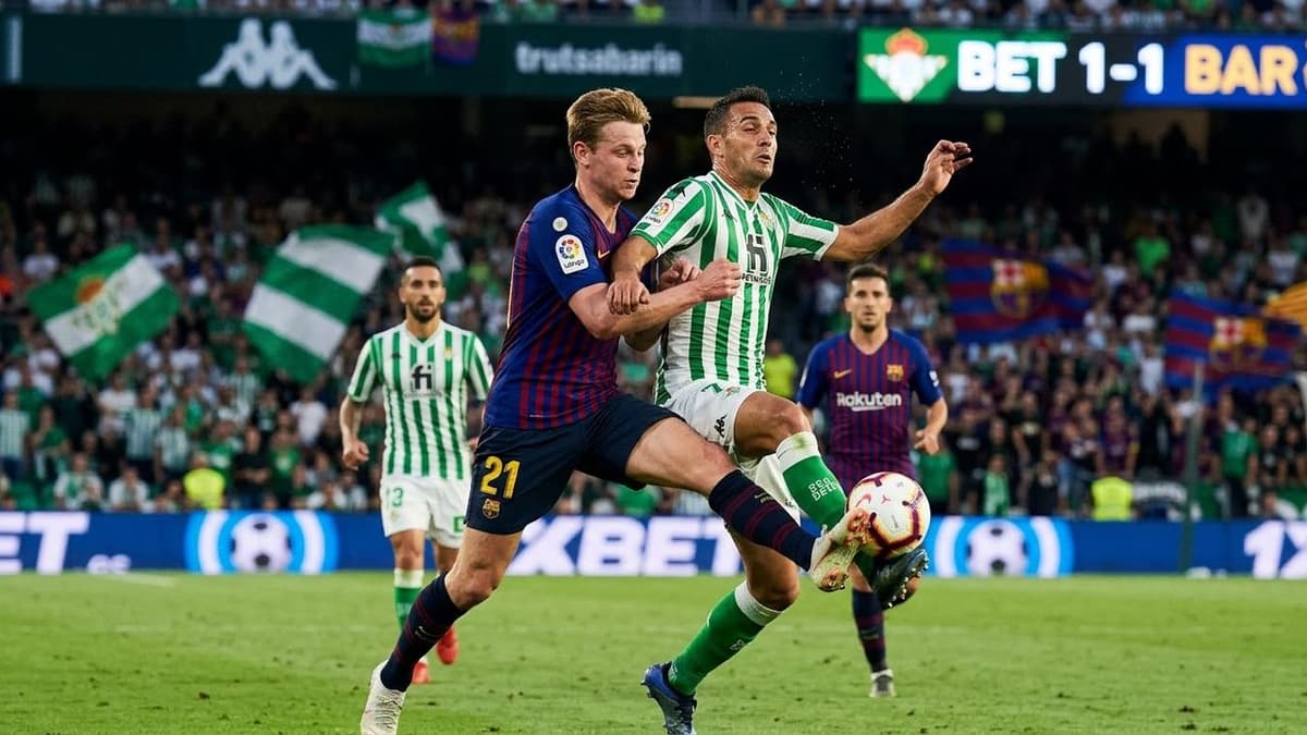 jugadores del Betis y del Barcelona disputan un balón durante un partido de LaLiga.s