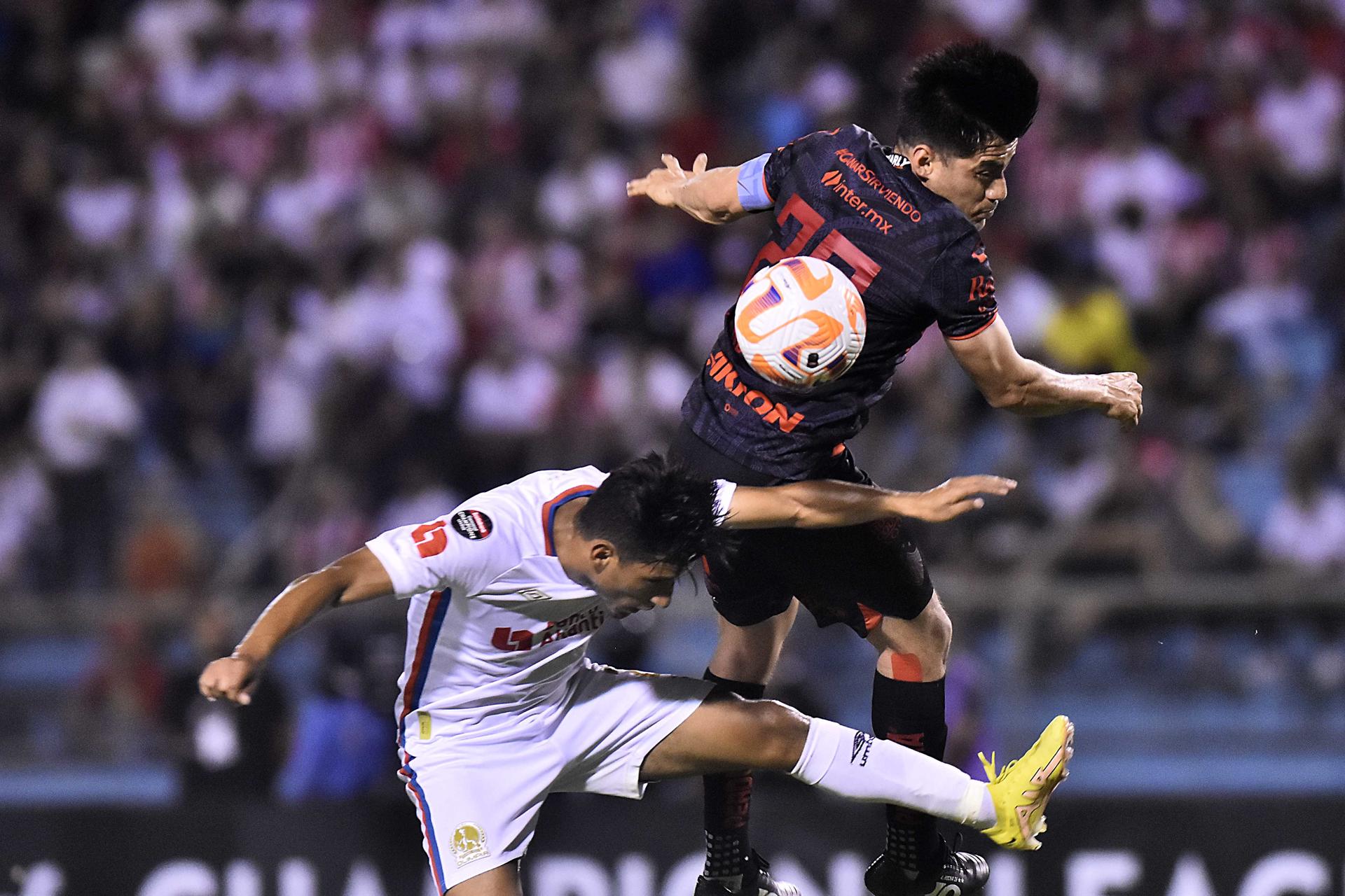 Aldo Rocha (d) del Atlas disputa el balón ante José Mario Pinto del Olimpia hoy, durante un partido de ida de los octavos de final de la Liga de Campeones de la CONCACAF, entre Olimpia de Honduras y Atlas de México, en el estadio Olímpico Metropólitano de San Pedro Sula (Honduras). EFE/ José Valle