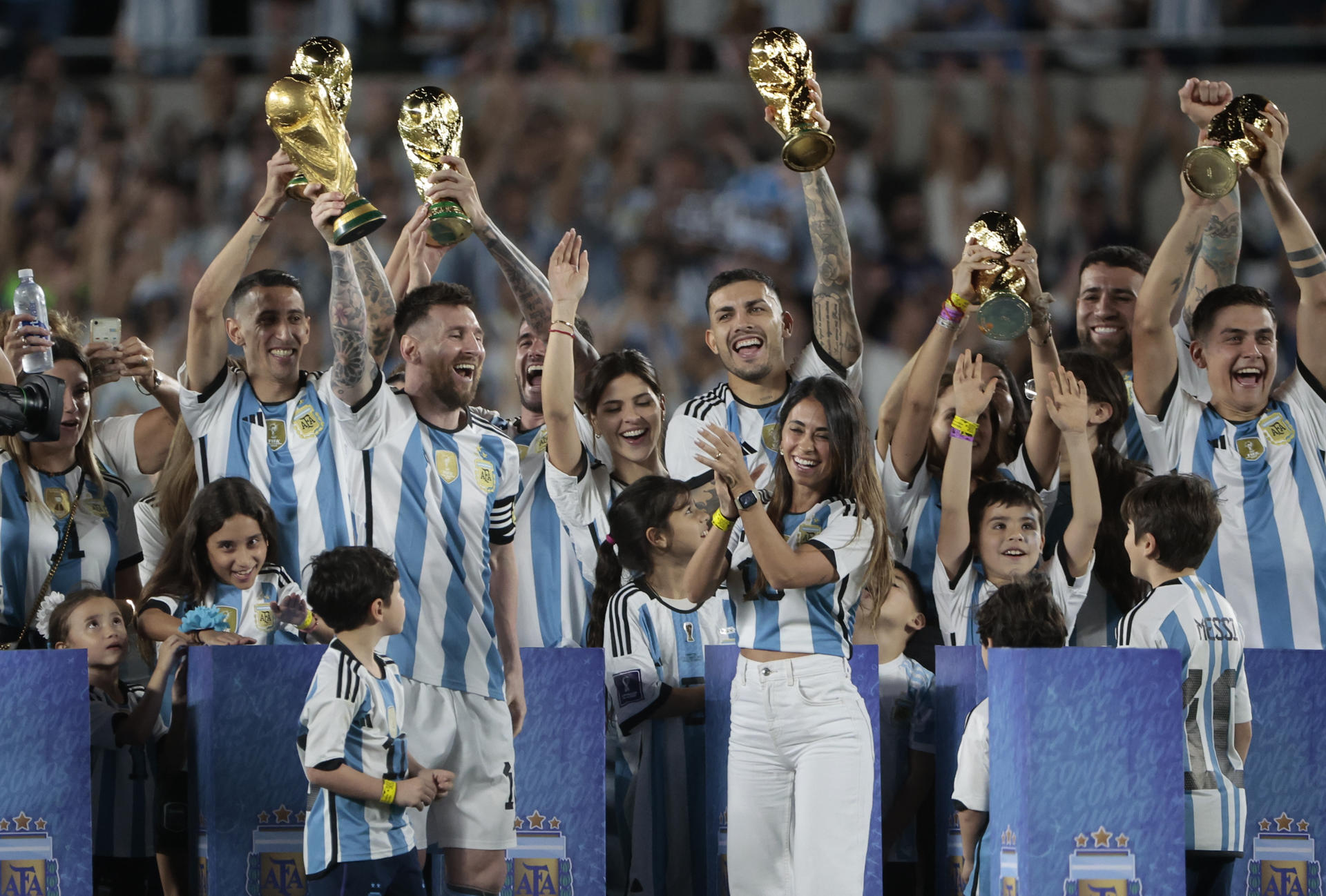 Lionel Messi (5i), capitán de la selección nacional de fútbol Argentina, junto a otros compañeros que ganaron el Mundial FIFA de Qatar 2022, fueron registrado este jueves, 23 de marzo, al celebrar con sus esposas e hijos, al final de un partido amistoso contra Panamá, en el estadio Monumental, en Buenos Aires (Argentina). EFE/Juan Ignacio Roncoroni 