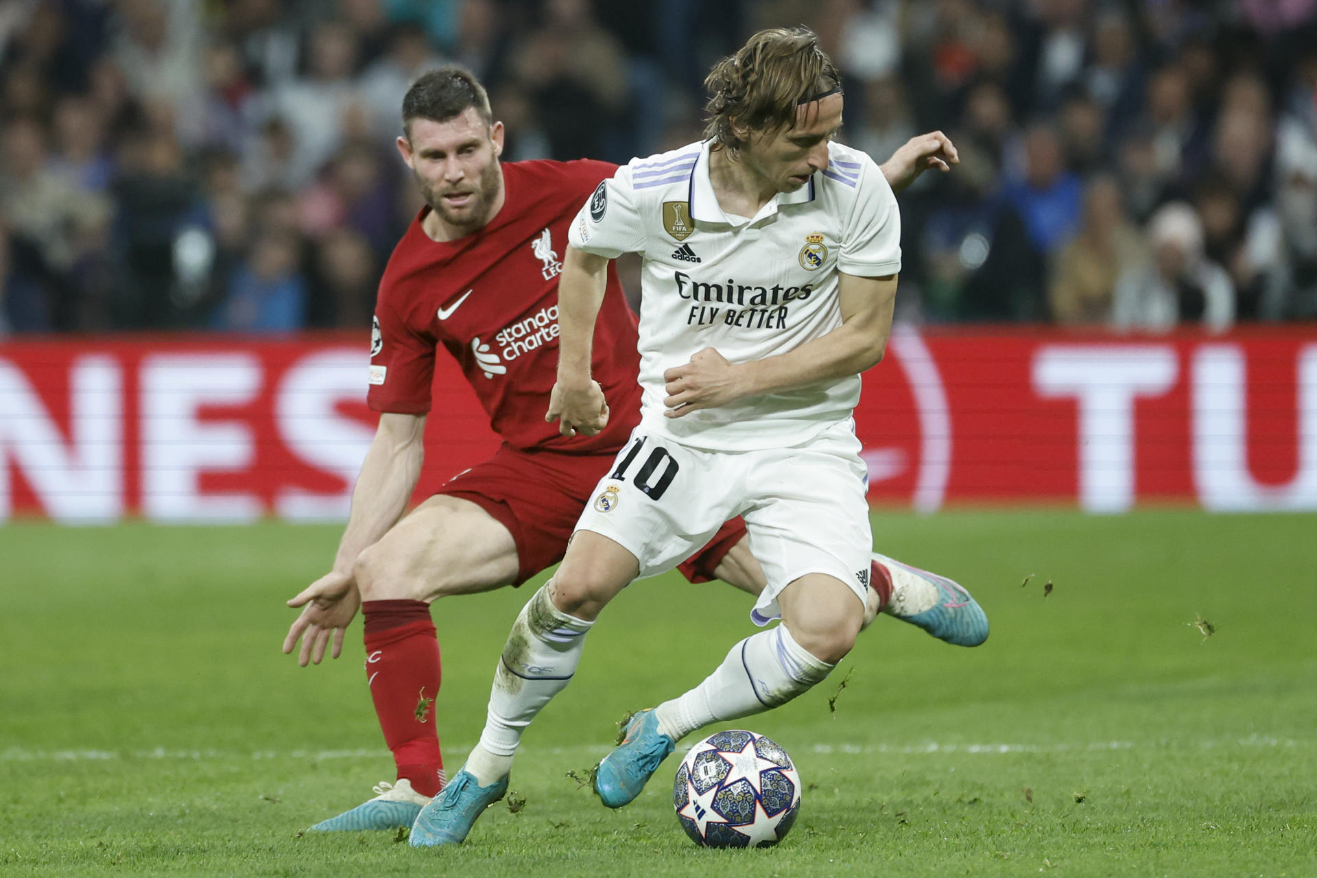 El centrocampista del Real Madrid Luka Modric (d) se escapa de James Milner, del Liverpool, durante el partido de vuelta de los octavos de final de la Liga de Campeones en el estadio Santiago Bernabéu, en Madrid. EFE/JUANJO MARTÍN 