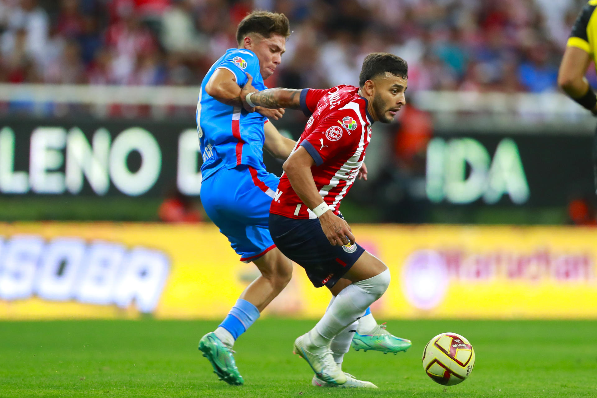 Alexis Vega (d) del Guadalajara disputa el balón con Rodrígo Huescas (i) de Cruz Azul este 22 de abril de 2023, durante un partido entre Guadalajara y Cruz Azul. EFE/ Francisco Guasco 