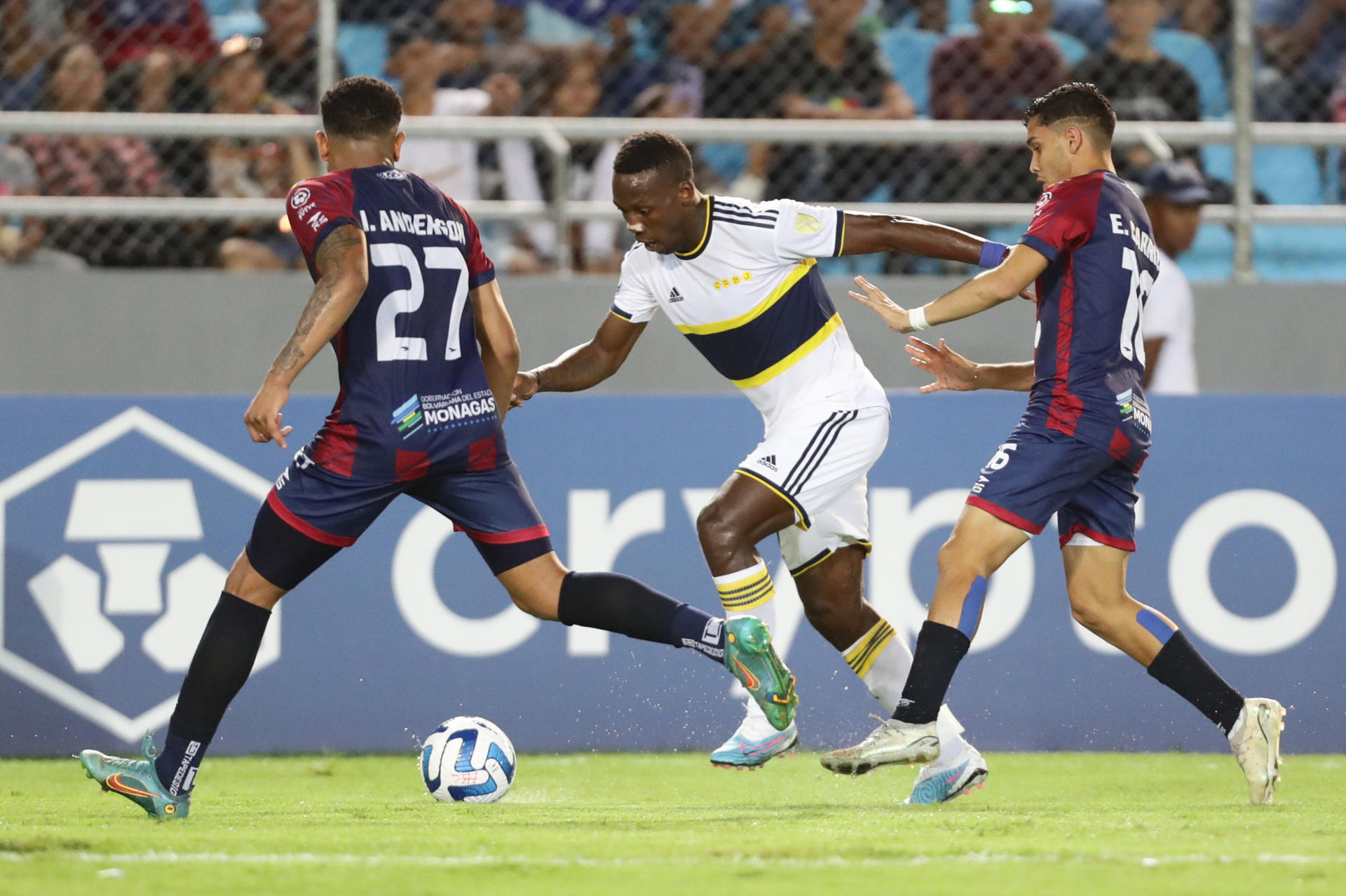 Iván Anderson (i), del Monagas de Venezuela, fue registrado este jueves, 6 de abril, al disputar un balón con Luis Advíncula (c), del Boca Juniors de Argentina, durante un partido del grupo F de la Copa Libertadores, en estadio Monumental de Maturín, en Maturín (Venezuela). EFE/Rayner Peña 