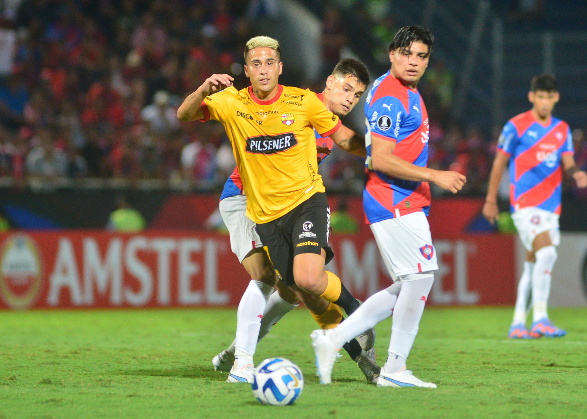 Damián Bobadilla (i) y Claudio Aquino (d) de Cerro disputan un balón con Christian Ortiz de Barcelona hoy, en un partido de la fase de grupos de la Copa Libertadores entre Cerro Porteño y Barcelona SC en el estadio General Pablo Rojas en Asunción (Paraguay). EFE/ Daniel Piris