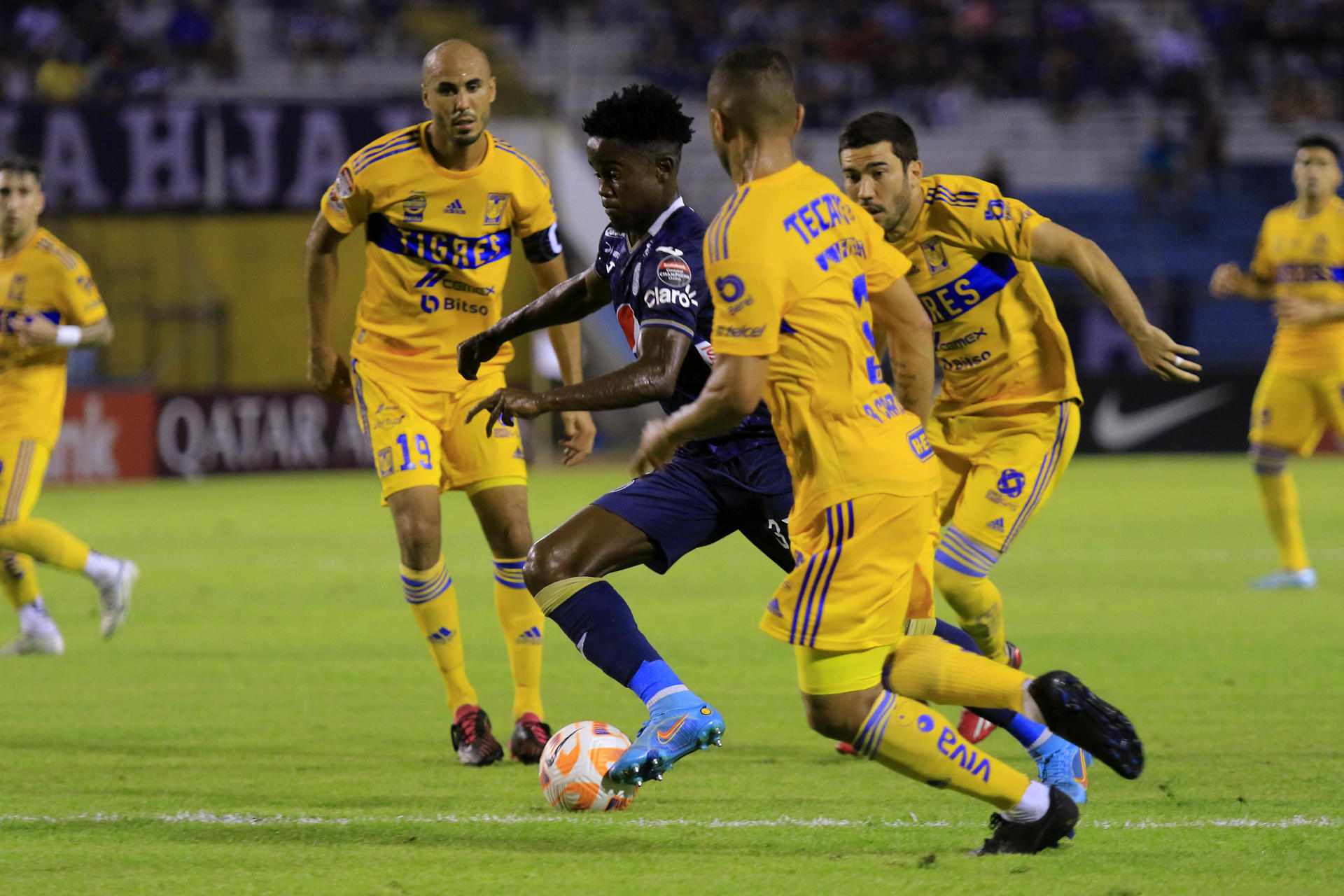 Jonathan Núñez (c), del Motagua de Honduras, fue registrado este miércoles, 5 de abril, al intentar superar la defensa de Tigres de México, durante el partido de ida de esta llave de los cuartos de final de la Liga de Campeones de la Concacaf, en el estadio Olímpico Metropolitano, en San Pedro Sula (Honduras). EFE/José Valle 