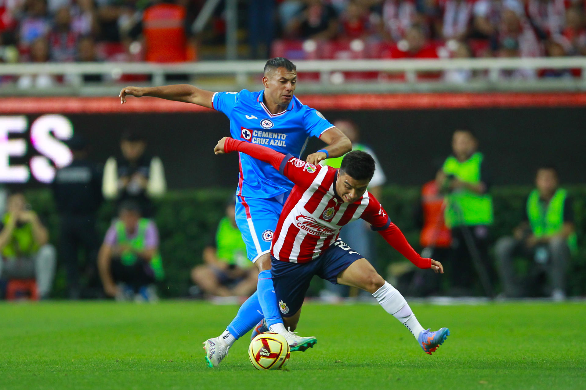 Fernando Beltrán (d) del Guadalajara disputa el balón con Julio Domínguez (i) de Cruz Azul este 22 de abril de 2023, durante un partido entre Guadalajara y Cruz Azul. EFE/ Francisco Guasco