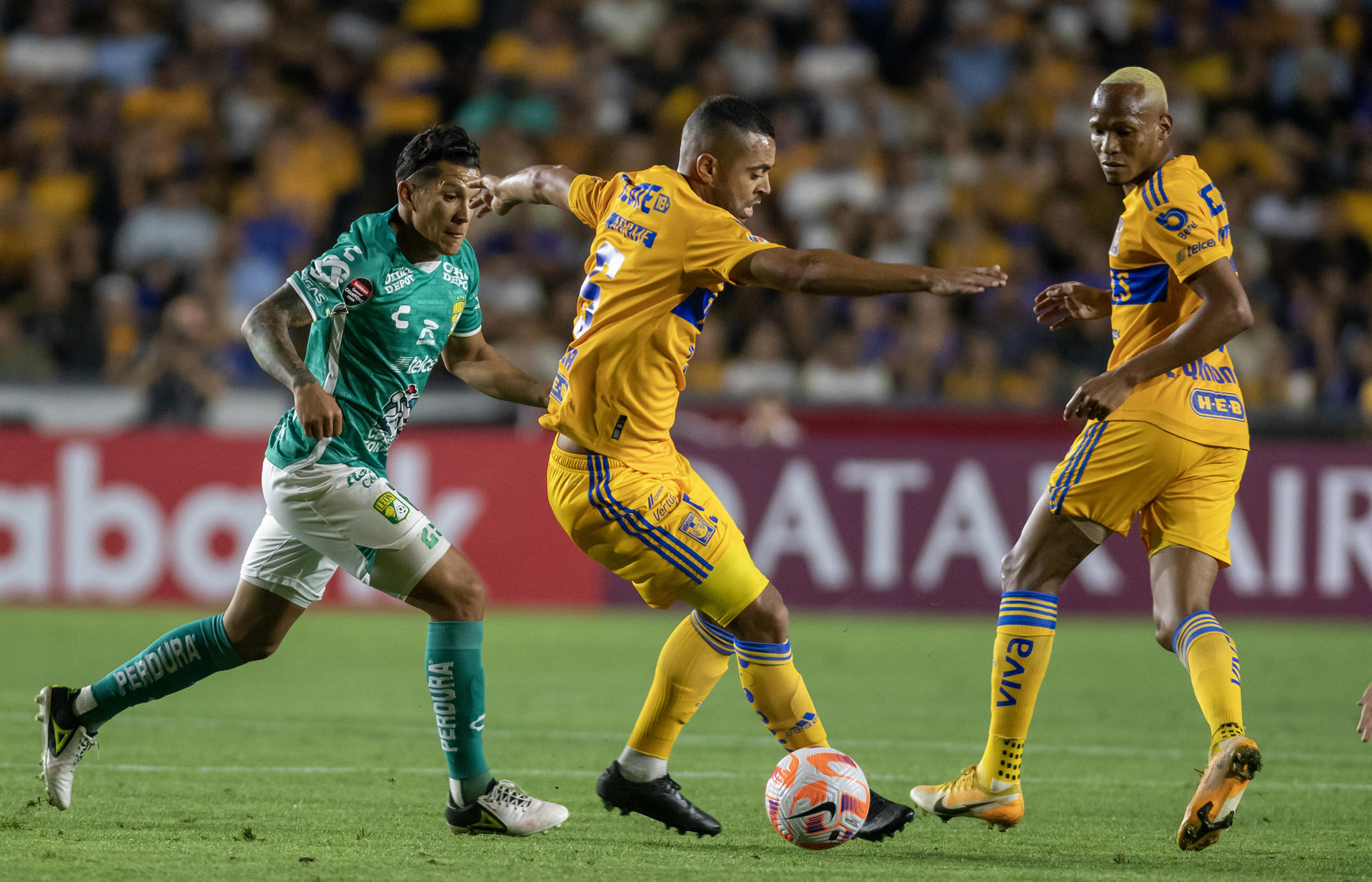 Rafael de Souza (c) de Tigres disputa el balón con Lucas romero (i) de León hoy, durante el partido de ida correspondiente a la semifinal de la liga de campeones de CONCACAF, entre Tigres y León, en el estadio Universitario de la ciudad de Monterrey. EFE/Miguel Sierra.