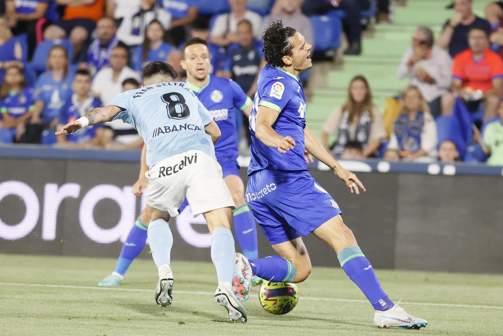 El delantero turco del Getafe, Enes Unal (d), ante el centrocampista del Celta, Fran Beltrán, en la jugada que ha significado el penalti a favor del equipo madrileño durante el encuentro correspondiente a la jornada 33 de primera división que disputarons en el Coliseum Alfonso Pérez, en Getafe. EFE / Mariscal. 