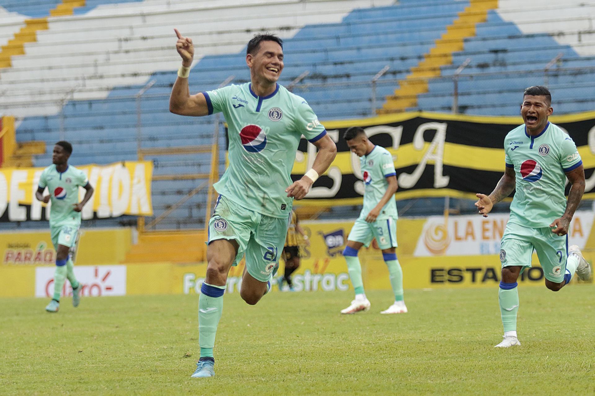 Fotografía de archivo en la que se registró a Roberto Moreira (i) al celebrar uno de los goles que anotó para el Motagua, en el estadio Francisco Morazán, en San Pedro Sula (Honduras). EFE/José Valle