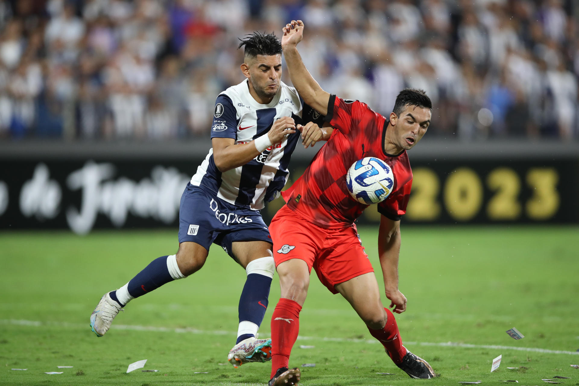 Carlos Zambrano (i) de Alianza disputa el balón con Alfio Oviedo de Libertad hoy en un partido de la fase de grupos de la Copa Libertadores entre Alianza Lima y Libertad en el estadio Alejandro Villanueva en Lima (Perú). EFE/ Paolo Aguilar
