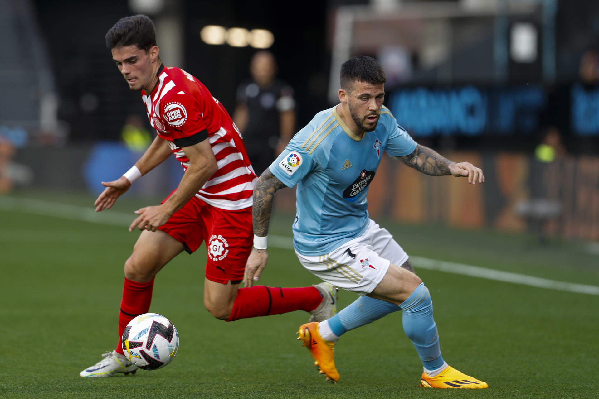 El delantero del Celta Carlos Pérez (d) pelea un balón con Miguel Gutierrez, del Girona, durante el partido de Liga en Primera División que Celta de Vigo y Girona FC disputaron en el estadio de Balaídos. EFE/Salvador Sas