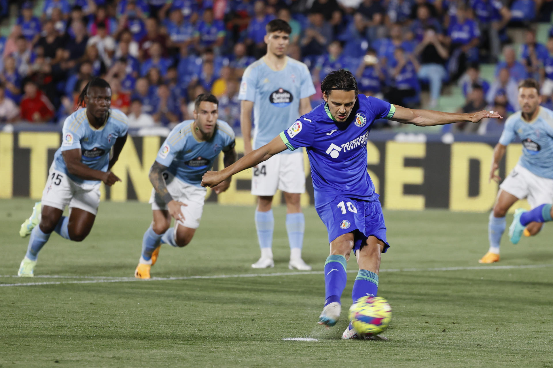 El delantero turco del Getafe, Enes Unal, golpea el balón desde el punto de penalti para conseguir el primer gol del equipo madrileño durante el encuentro correspondiente a la jornada 33 de primera división que disputaron frente al Celta en el Coliseum Alfonso Pérez, en Getafe. EFE / Marical.