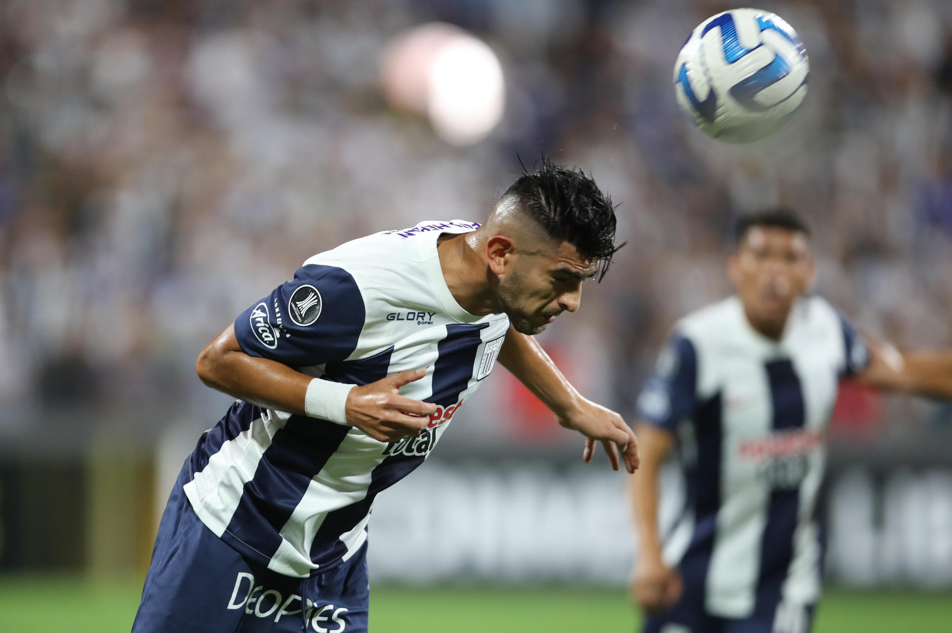 Carlos Zambrano de Alianza rechaza el balón hoy en un partido de la fase de grupos de la Copa Libertadores entre Alianza Lima y Libertad en el estadio Alejandro Villanueva en Lima (Perú). EFE/ Paolo Aguilar
