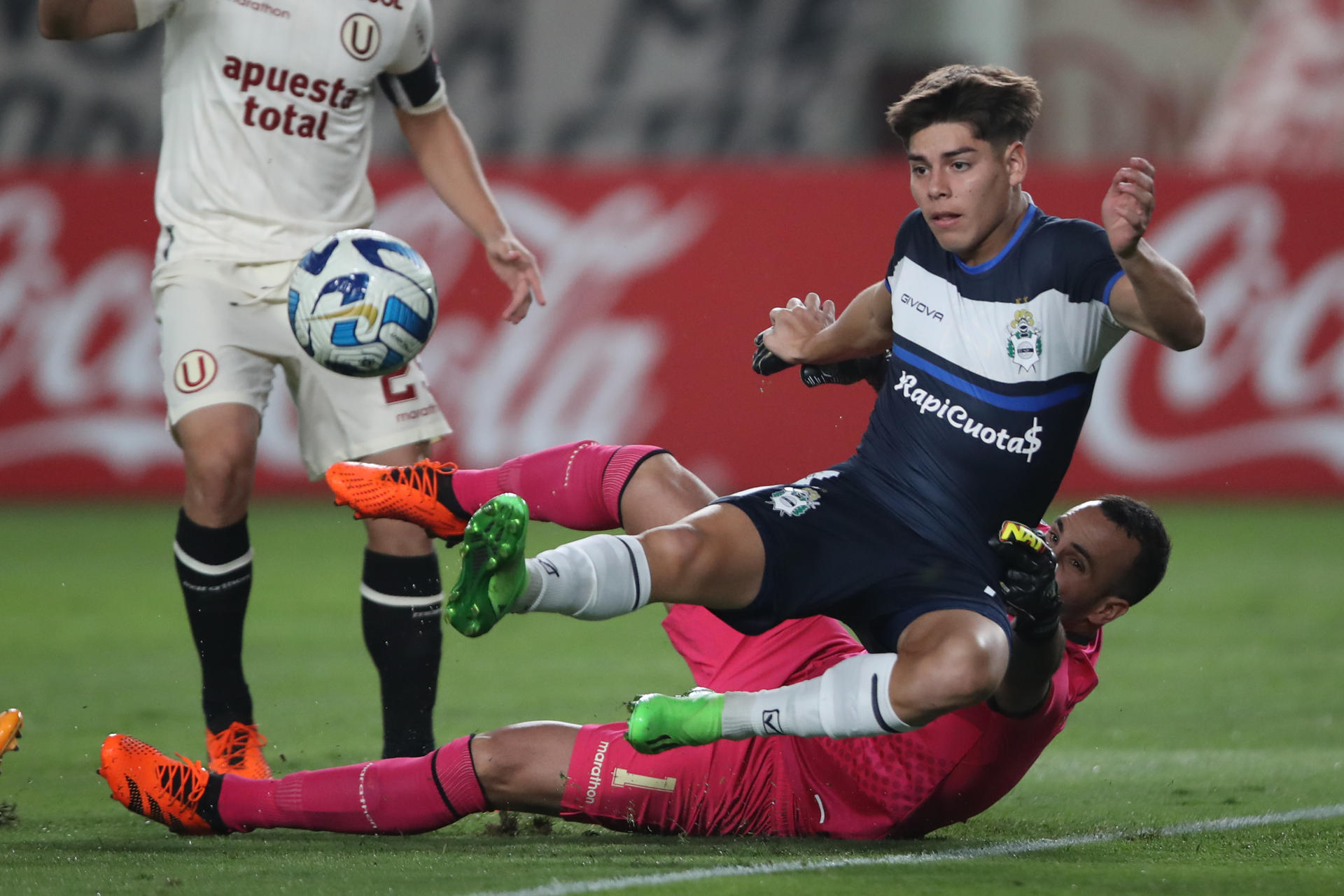 José Carvallo (abajo) de Universitario disputa el balón con Benjamín Domínguez (2-i) de Gimnasia hoy, en un partido de fase de grupos de la Copa Sudamericana entre Universitario y Gimnasia y Esgrima en el estadio Monumental en Lima (Perú). EFE/Paolo Aguilar 