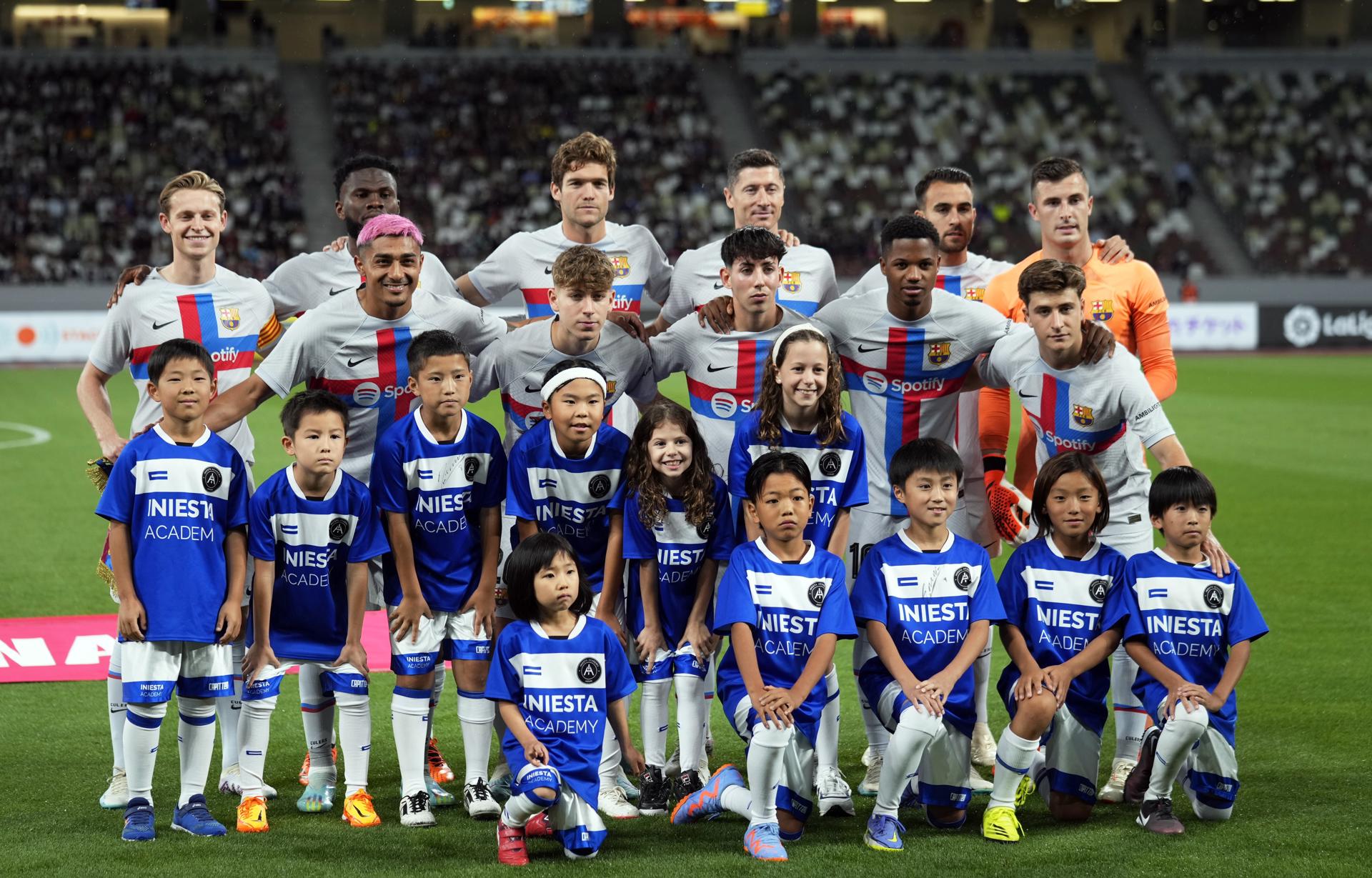 Los jugadores del FC Barcelona posan para una foto con niños de la Academia Iniesta antes del partido amistoso de fútbol entre el Vissel Kobe y el FC Barcelona en el Estadio Nacional de Tokio.EFE/EPA/FRANCK ROBICHON 