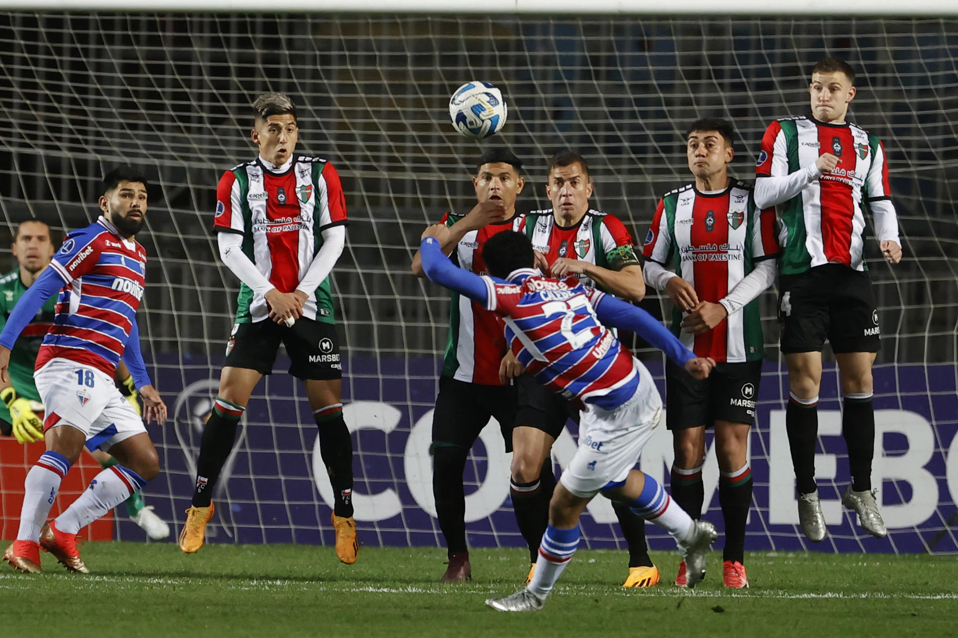 Calebe Gonçalves Ferreira da Silva (abajo) de Fortaleza le pega al balón hoy, durante un partido por el grupo H de la Copa Sudamericana entre Palestino y Fortaleza, en el estadio El Teniente, en Rancagua (Chile). EFE/Elvis González 