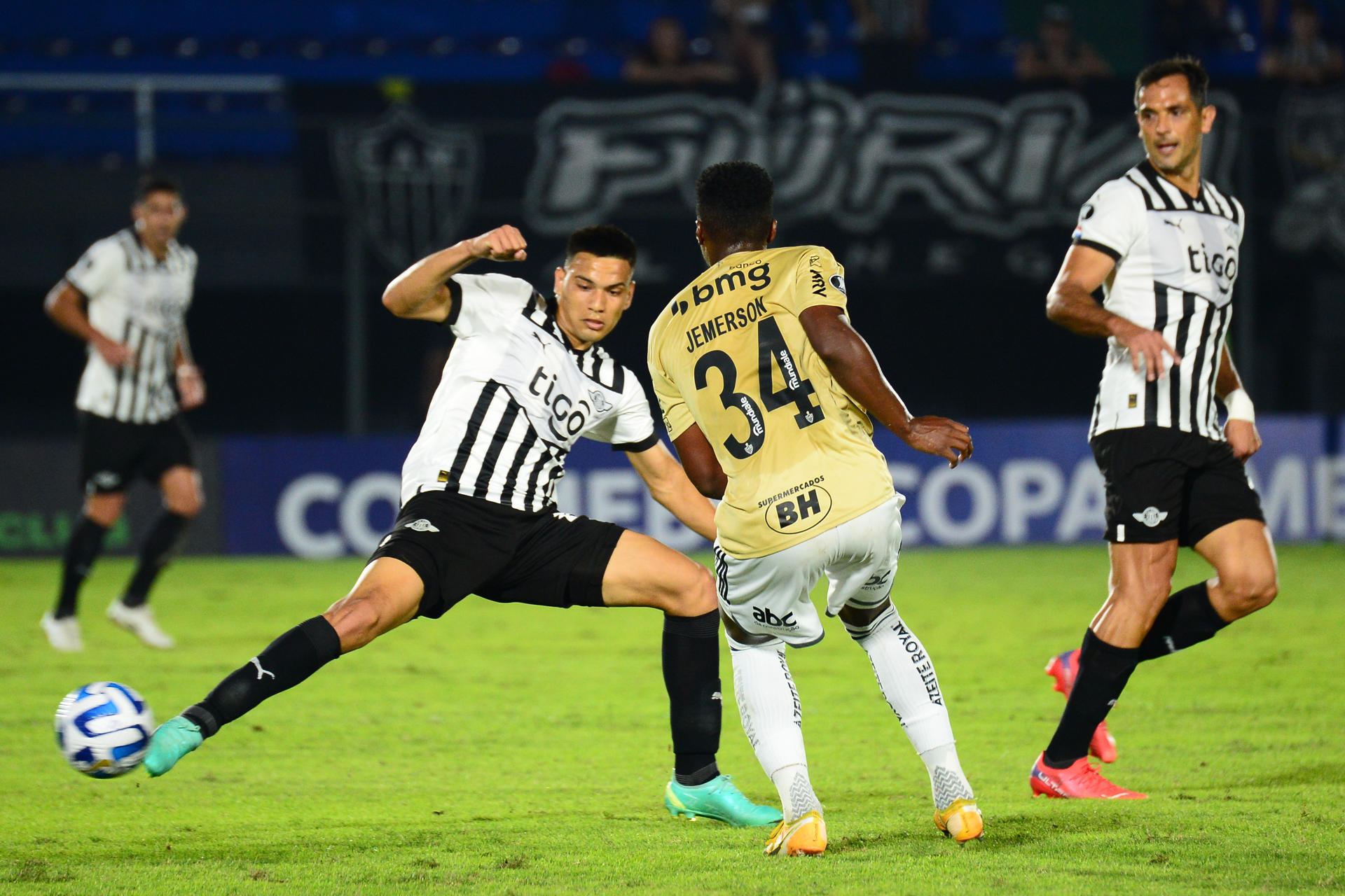 Diego Gómez (i) de Libertad disputa un balón con Vitor Graziani (c) de Mineiro hoy, en un partido de la fase de grupos de la Copa Libertadores entre Libertad y Atlético Mineiro en el estadio Defensores del Chaco en Asunción (Paraguay). EFE/ Daniel Piris