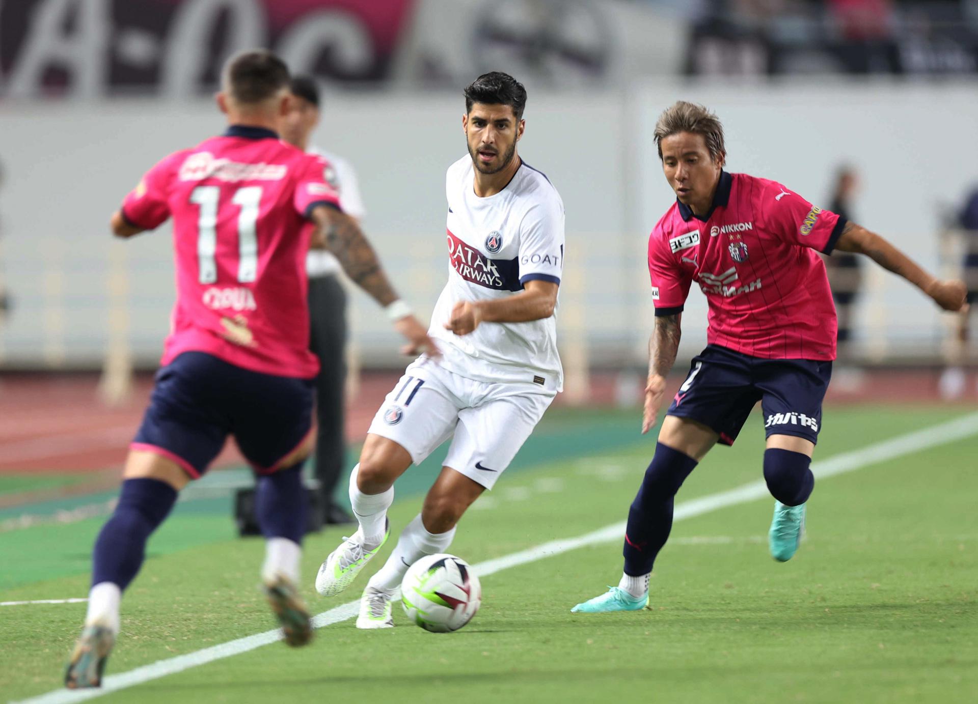 Marco Asensio entre Jordy Croux (izq) y Riku Matsuda (dch) durante el amistoso PSG-Cerezo Osaka. EFE/EPA/JIJI PRESS 