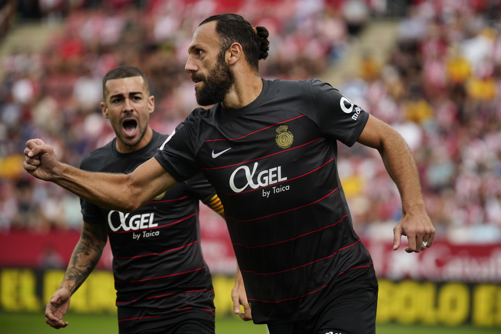 Vedat Muriqi (c), del Mallorca, celebra tras marcar ante el Girona durante el encuentro liguero celebrado en el Estadi Montilivi en Girona, este sábado. EFE/ David Borrat 