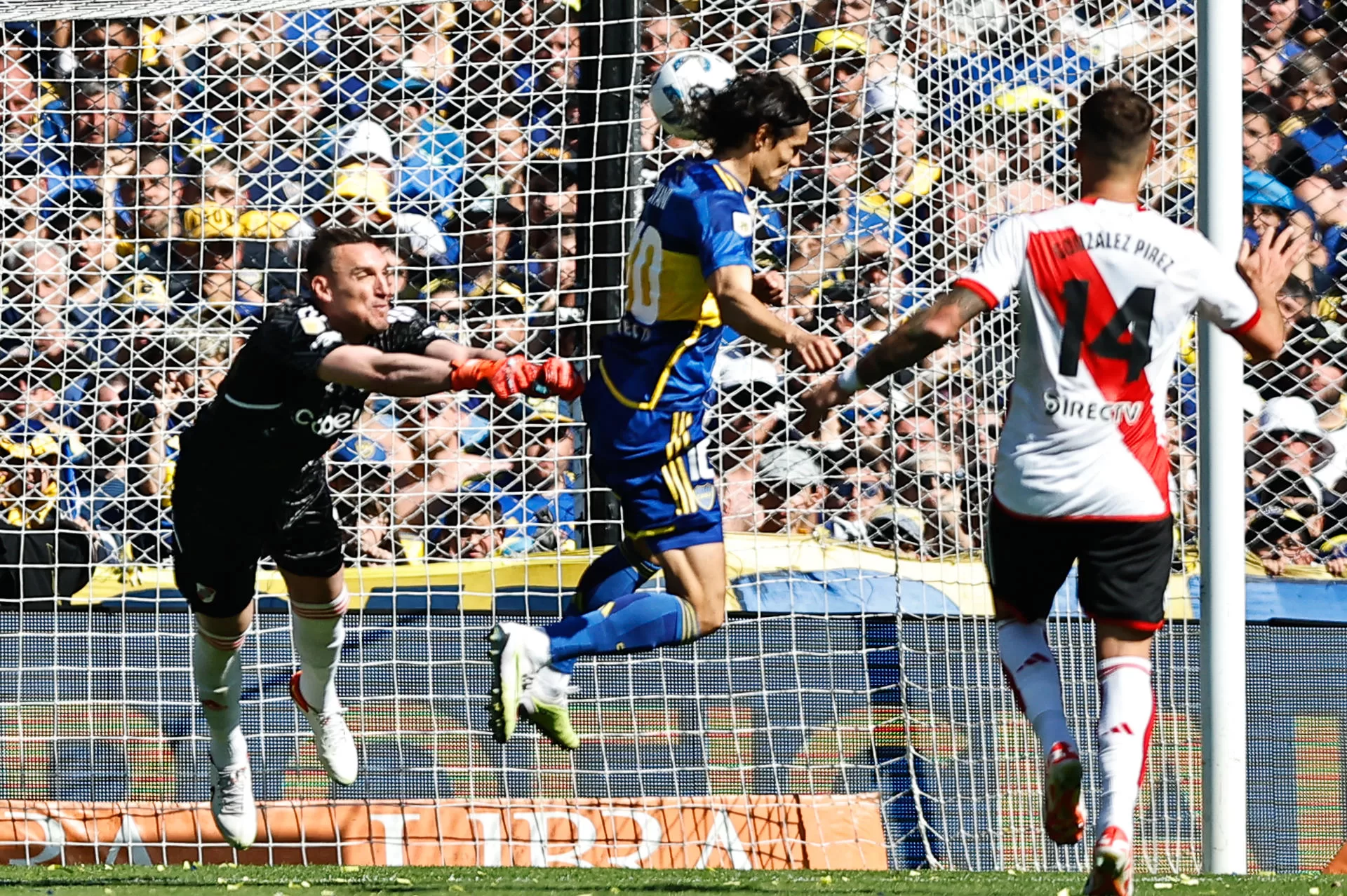 El jugador de Boca Juniors Edinson Cavani gana el balón ante el portero Franco Armani (i) en una jugada que terminó en un gol invalidado por fuera de lugar hoy, durante un partido por la Primera División del fútbol argentino, en el estadio La Bombonera de Buenos Aires (Argentina). EFE/ Juan Ignacio Roncoroni 