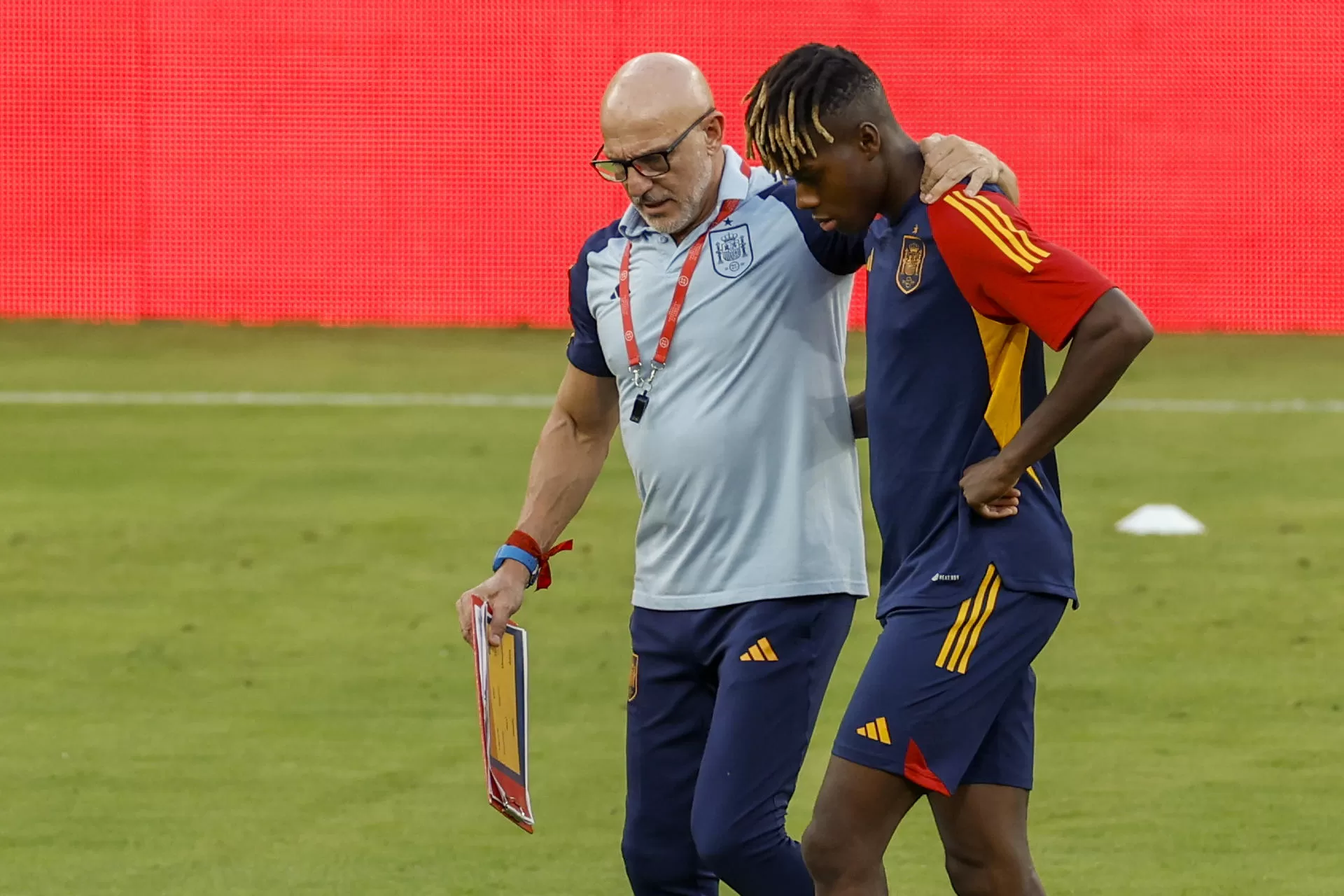 El seleccionador nacional, Luis de la Fuente (i), conversa con el delantero Nico Williams (d) durante el entrenamiento del equipo celebrado en Sevilla, en la víspera del encuentro de clasificación para la Eurocopa de 2024 ante Escocia en el estadio de La Cartuja. EFE/ Julio Muñoz