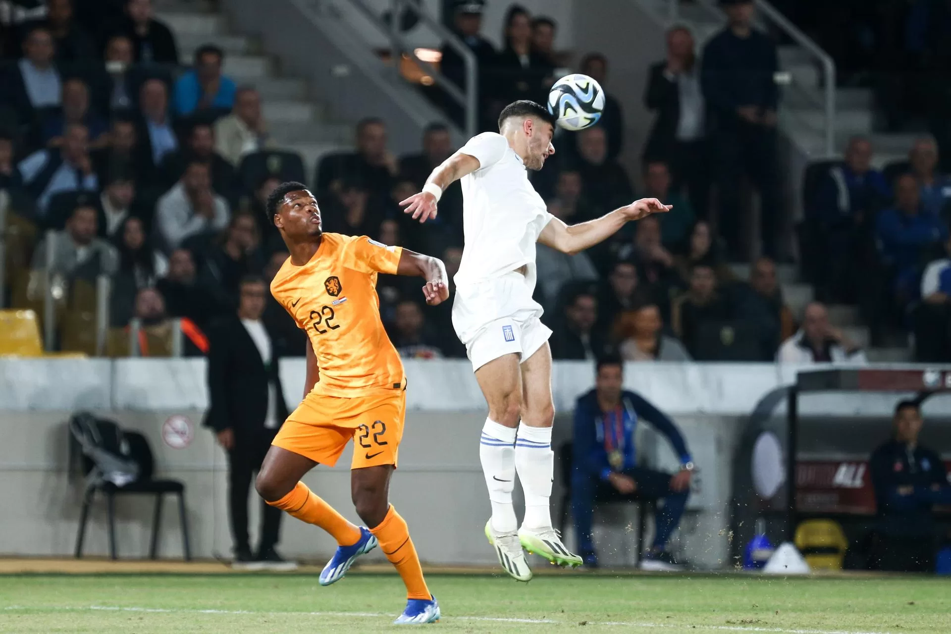 El griego Konstantinos Koulierakiscabecea el ablón delante del neerlandés Denzel Dumfries durante el partido del grupo B jugado en Atenas correspondiente a la clasificación para la Eurocopa de Alemania de 2024. EFE/EPA/Georgia Panagopoulou 