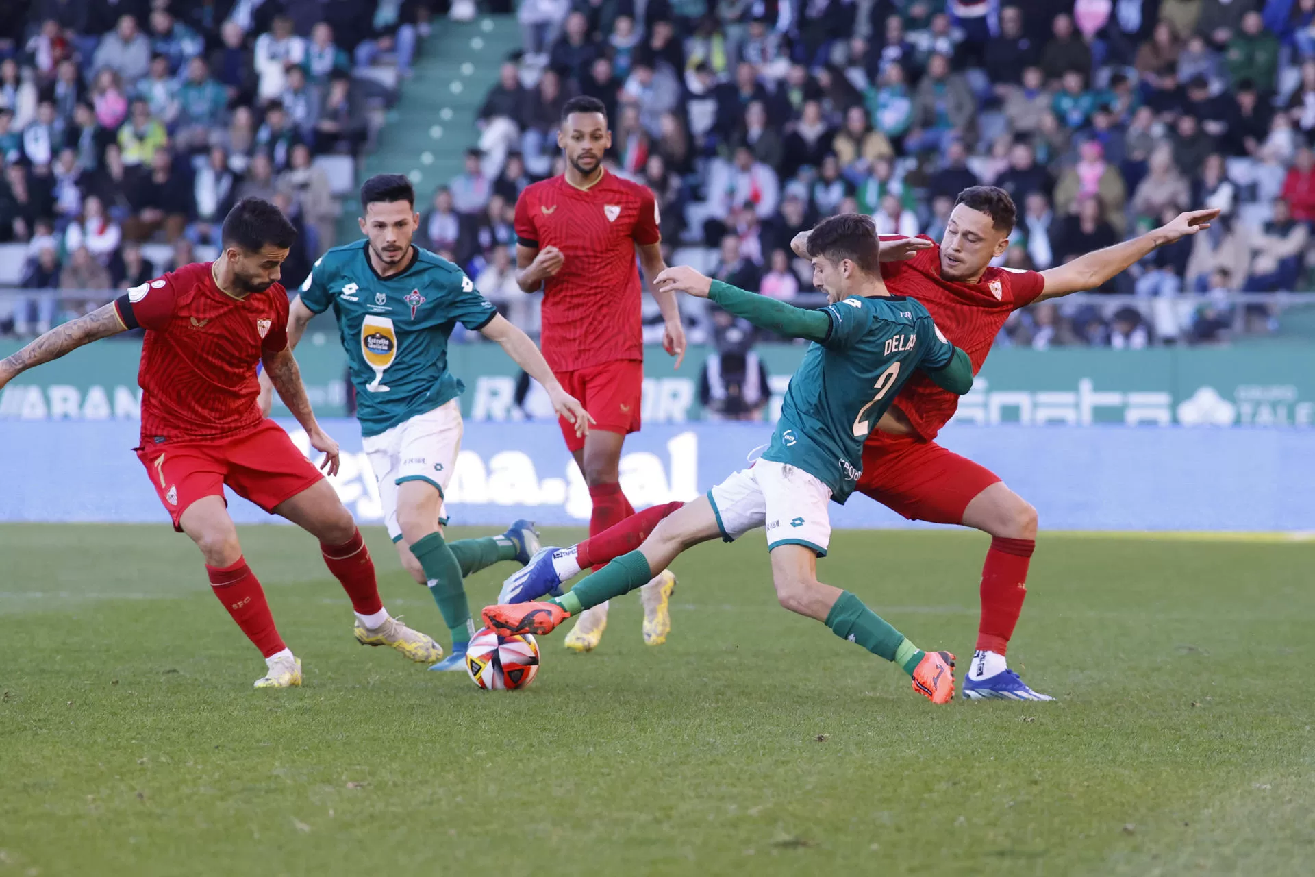 El defensa Julián Delmás (2d) del Racing Ferrol disputa un balón ante el delantero Lucas Ocampos (d) del Sevilla este domingo, durante un partido de dieciseisavos de final de la Copa del Rey, entre el Racing de Ferrol y el Sevilla, en el estadio de A Malata en Ferrol (Galicia). EFE/ Kiko Delgado
