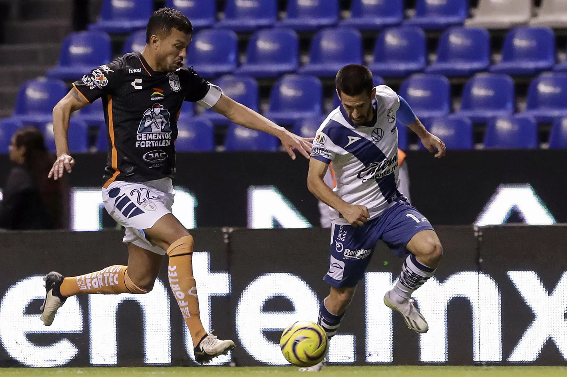 Fernando Navarro (d) de Puebla disputa un balón con Gustavo Cabral de Pachuca, durante un partido de la jornada 9 del torneo Clausura 2024 de la Liga MX del fútbol mexicano este martes, en el estadio Cuauhtémoc, en Puebla (México). EFE/Hilda Ríos