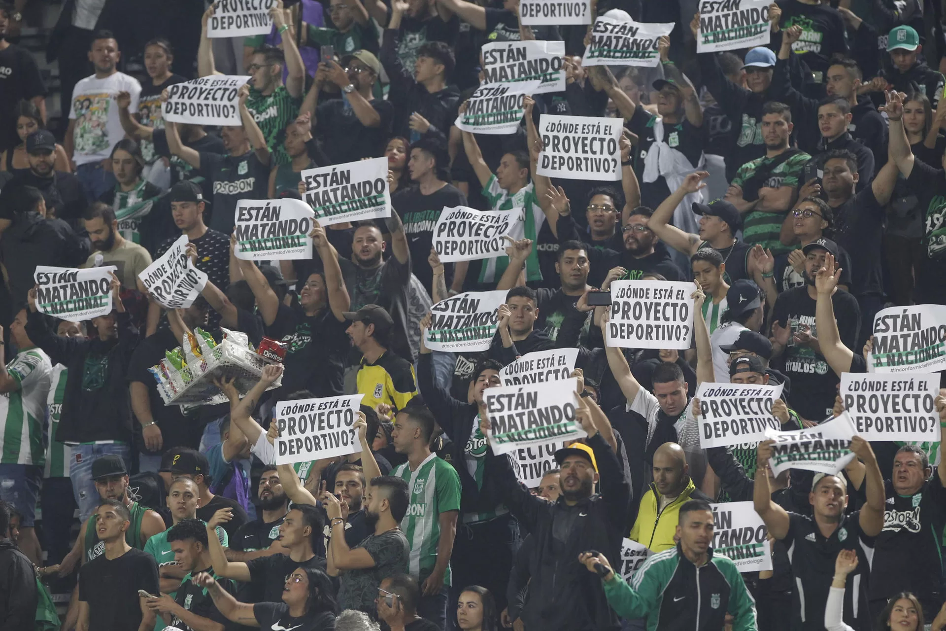 Hinchas de Atlético Nacional sostienen carteles de protesta en un partido de segunda fase de la Copa Libertadores entre Atlético Nacional y Club Nacional este miércoles, en el estadio Atanasio Girardot en Medellín (Colombia). EFE/Luis Eduardo Noriega Arboleda 