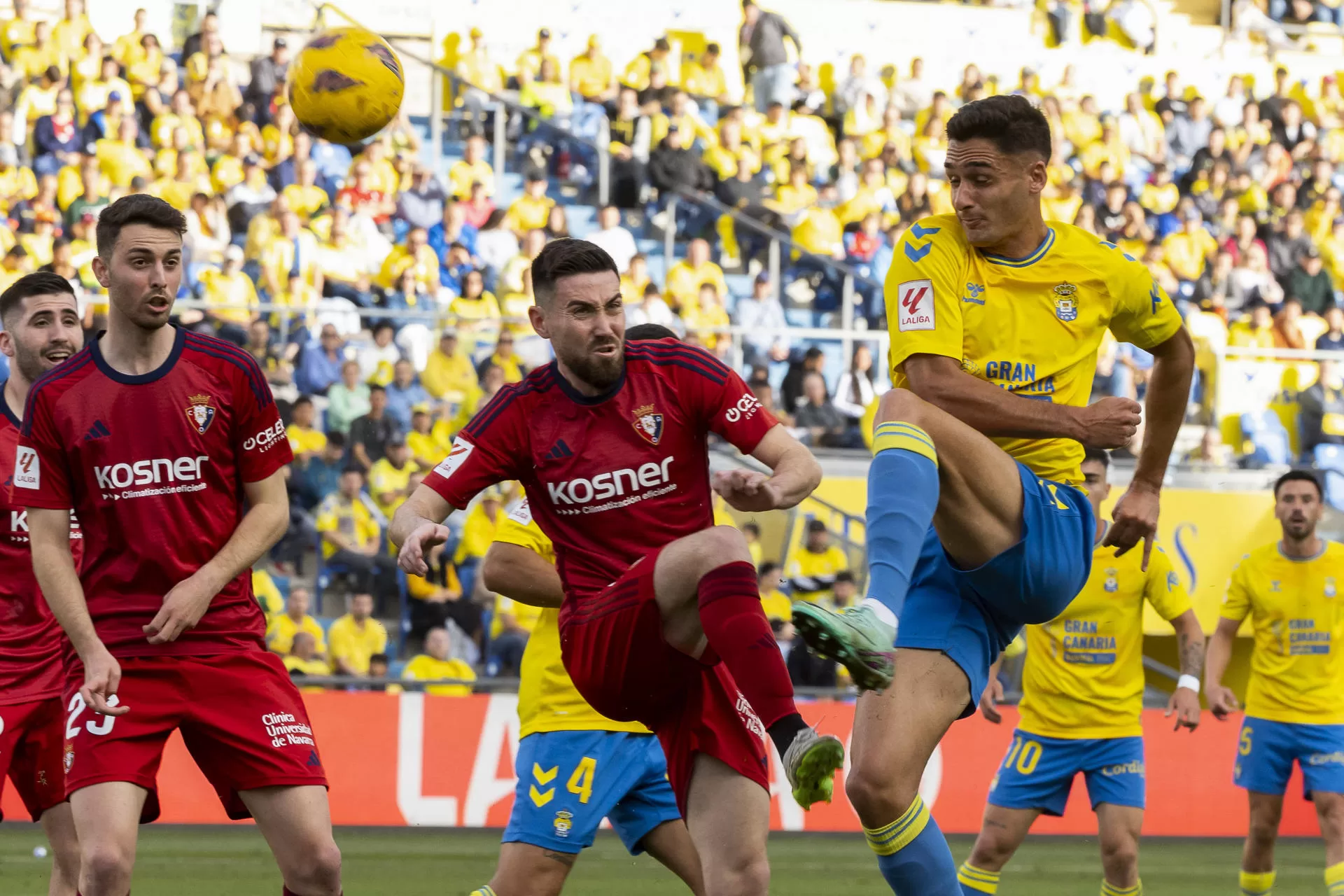 El defensa de Las Palmas Sergi Cardona (d) pelea un balón con Moi Gómez (c), de Osasuna, durante el partido de Liga que UD Las Palmas y CA Osasuna en el estadio de Gran Canaria. EFE/Quique Curbelo 