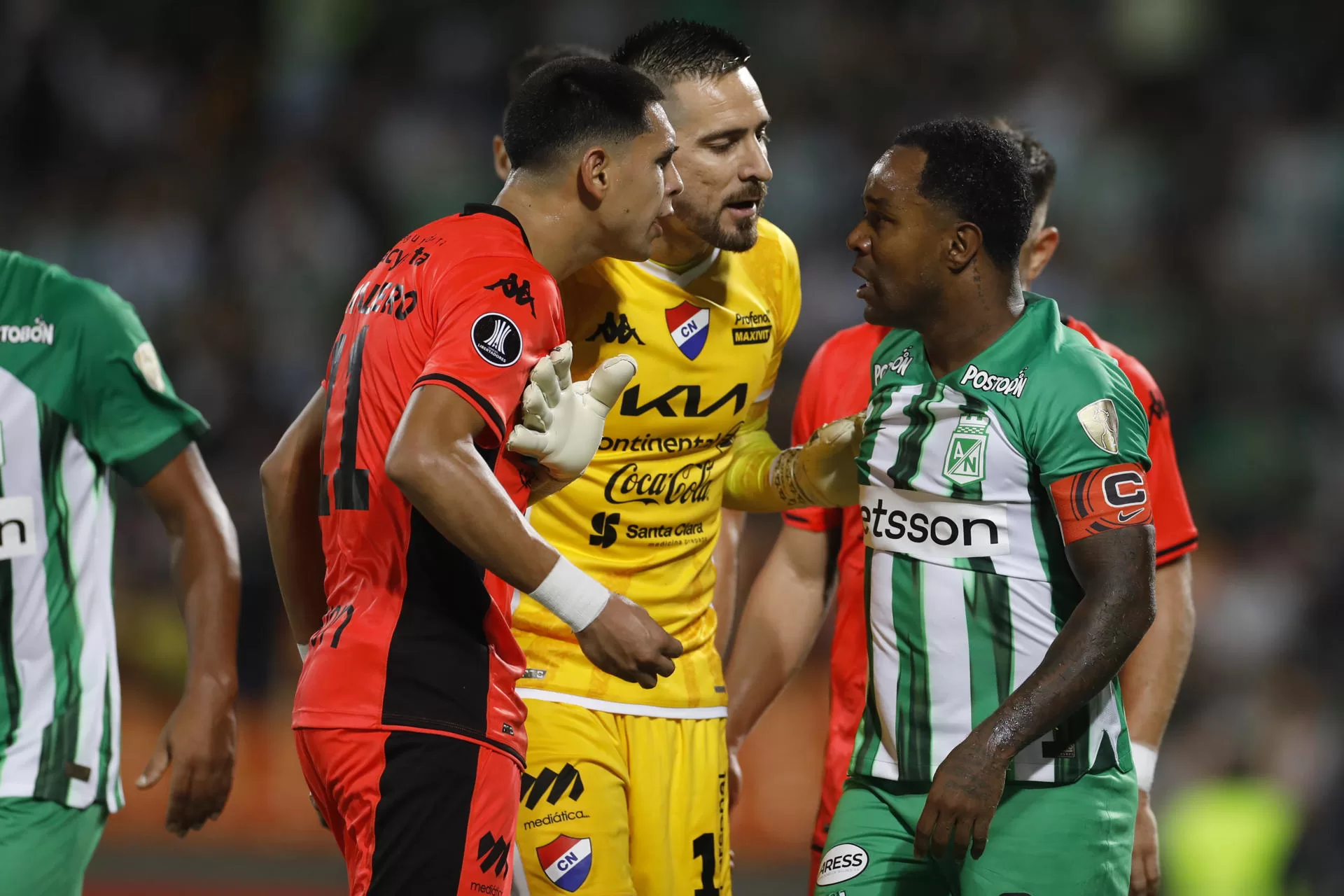Dorlan Pabón (d) de Atlético Nacional discute con Gustavo Caballero (i) y Antony Silva portero de Nacional este miércoles, en un partido de la segunda fase de la Copa Libertadores entre Atlético Nacional y Club Nacional este miércoles, en el estadio Atanasio Girardot en Medellín (Colombia). EFE/Luis Eduardo Noriega Arboleda 