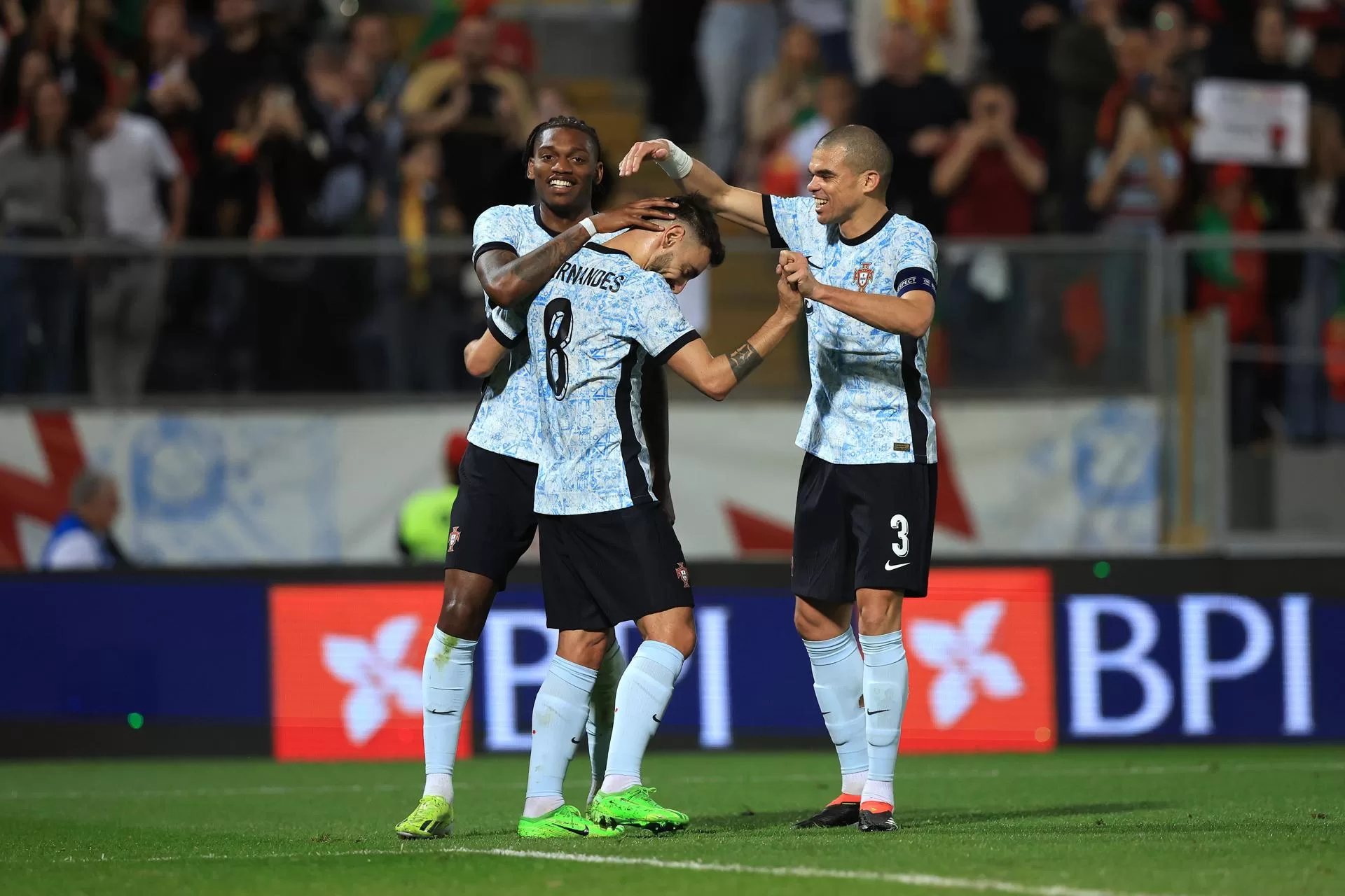 Los jugadores de la selección portuguesa de fútbol Rafael Leao (i) y Pepe (d) fueron registrados este jueves, 21 de marzo, al felicitar a su compañero Bruno Fernandes (c), luego de que le anotara el 3-0 a Suecia, durante un partido amistoso, en Guimaraes (Portugal). EFE/Estela Silva 