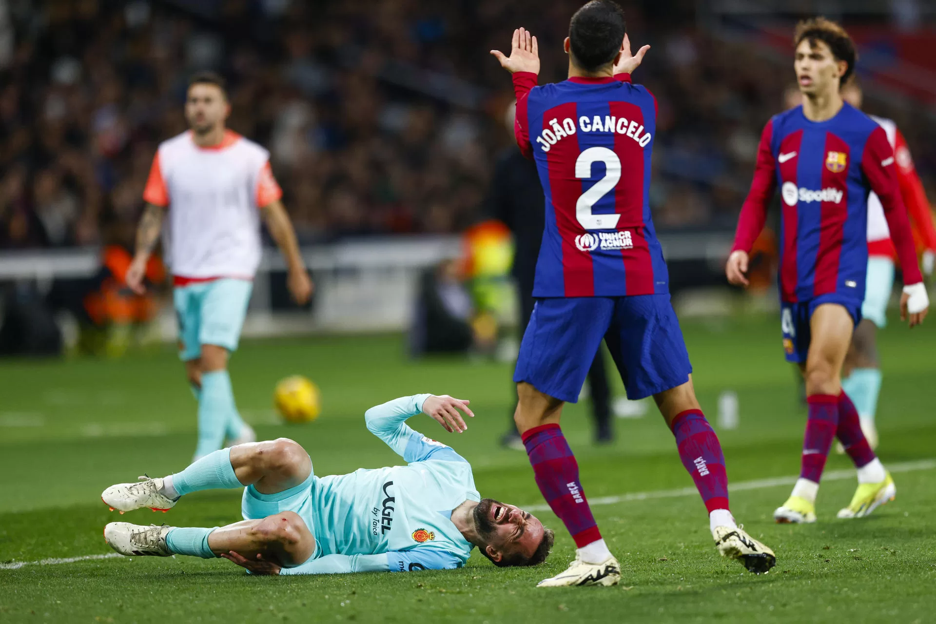 El centrocampista del Mallorca Sergi Darder se duele ante el defensa portugués del FC Barcelona Joao Cancelo.EFE / Quique García.