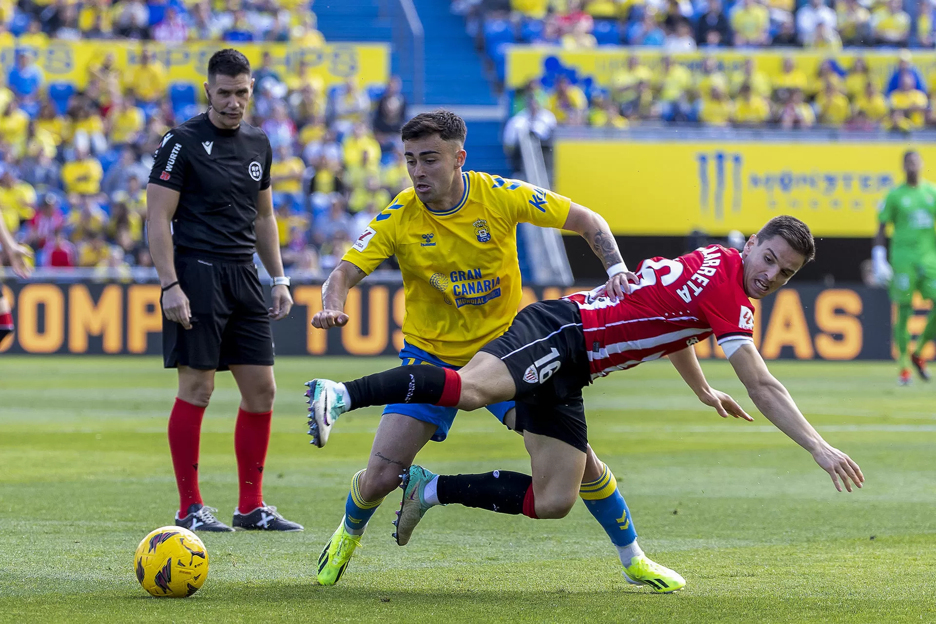 El centrocampista de la UD Las Palmas Alberto Moleiro (c) controla un balón ante el centrocampista del Athetic Club Iñigo Ruiz de Galarreta durante un partido correspondiente a la jornada 28 en LaLiga EA Sports disputado este domingo entre la UD Las Palmas y el Athletic Club en el estadio de Gran Canaria en Las Palmas de Gran Canaria. EFE/ Quique Curbelo 