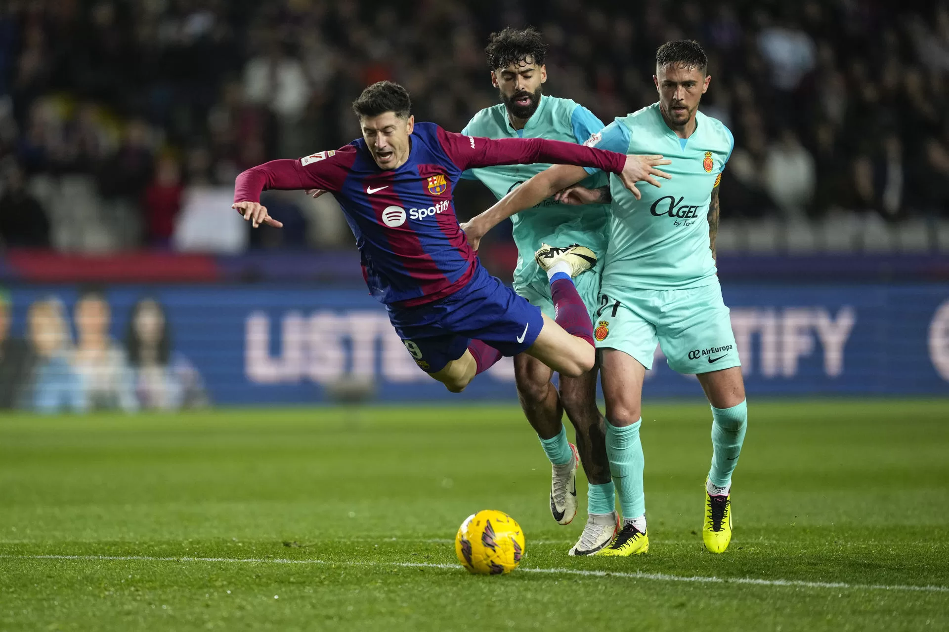 Robert Lewandowski (i), cae ante los jugadores del Mallorca, Antonio Raillo (d) y el portugués Samu Costa EFE / Quique García.