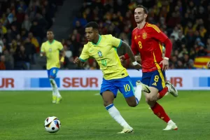 El delantero de la selección brasileña Rodrygo Goes (i) se escapa de Fabián Ruiz, de la selección española, durante el partido amistoso que las selecciones nacionales de fútbol de España y Brasil disputan hoy martes en el estadio Santiago Bernabéu, en Madrid. EFE/Mariscal