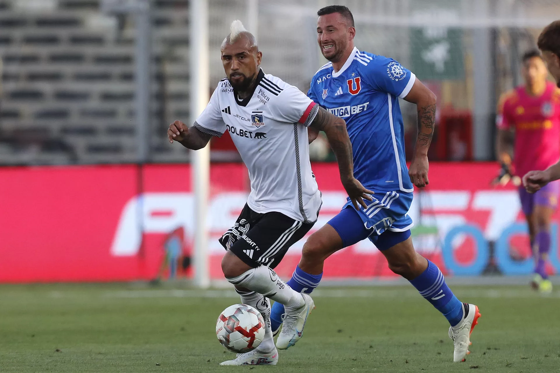 Arturo Vidal (i) de Colo-Colo disputa el balón con Luciano Pons (d) de U. de Chile durante el partido valido por la cuarta fecha del campeonato nacional chileno entre Club Universidad de Chile y Club Colo-Colo este domingo, en el Estadio Monumental en Santiago (Chile). EFE/ Osvaldo Villarroel