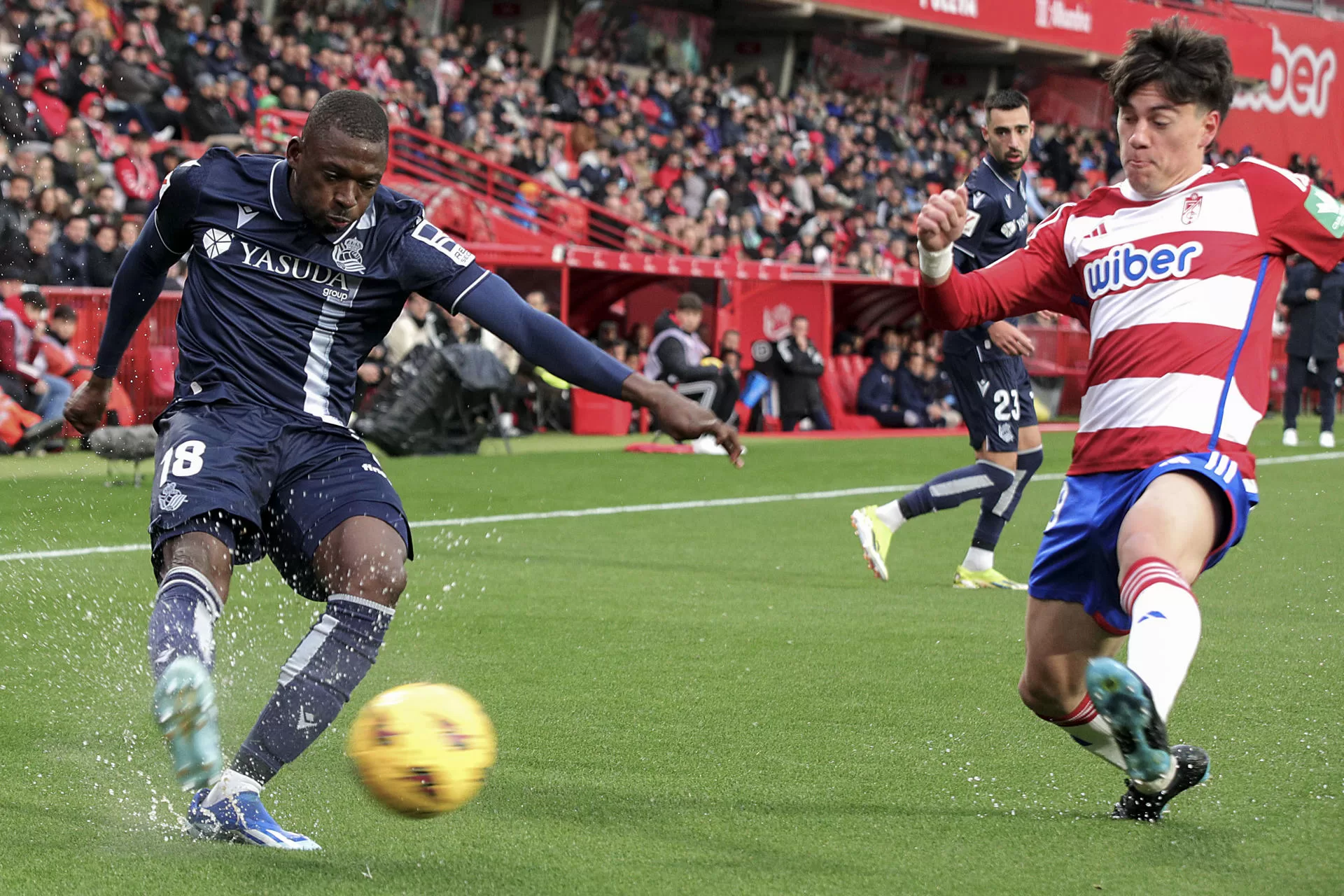 GRANADA, 09/03/2024.- El defensa de la Real Sociedad Hamari Traoré (i) centra el balón defendido por el uruguayo Facundo Pellistri, del Granada CF, durante el partido de la jornada 28 de LaLiga en el estadio Nuevo Los Carmenes, en Granada. EFE/Pepe Torres. 