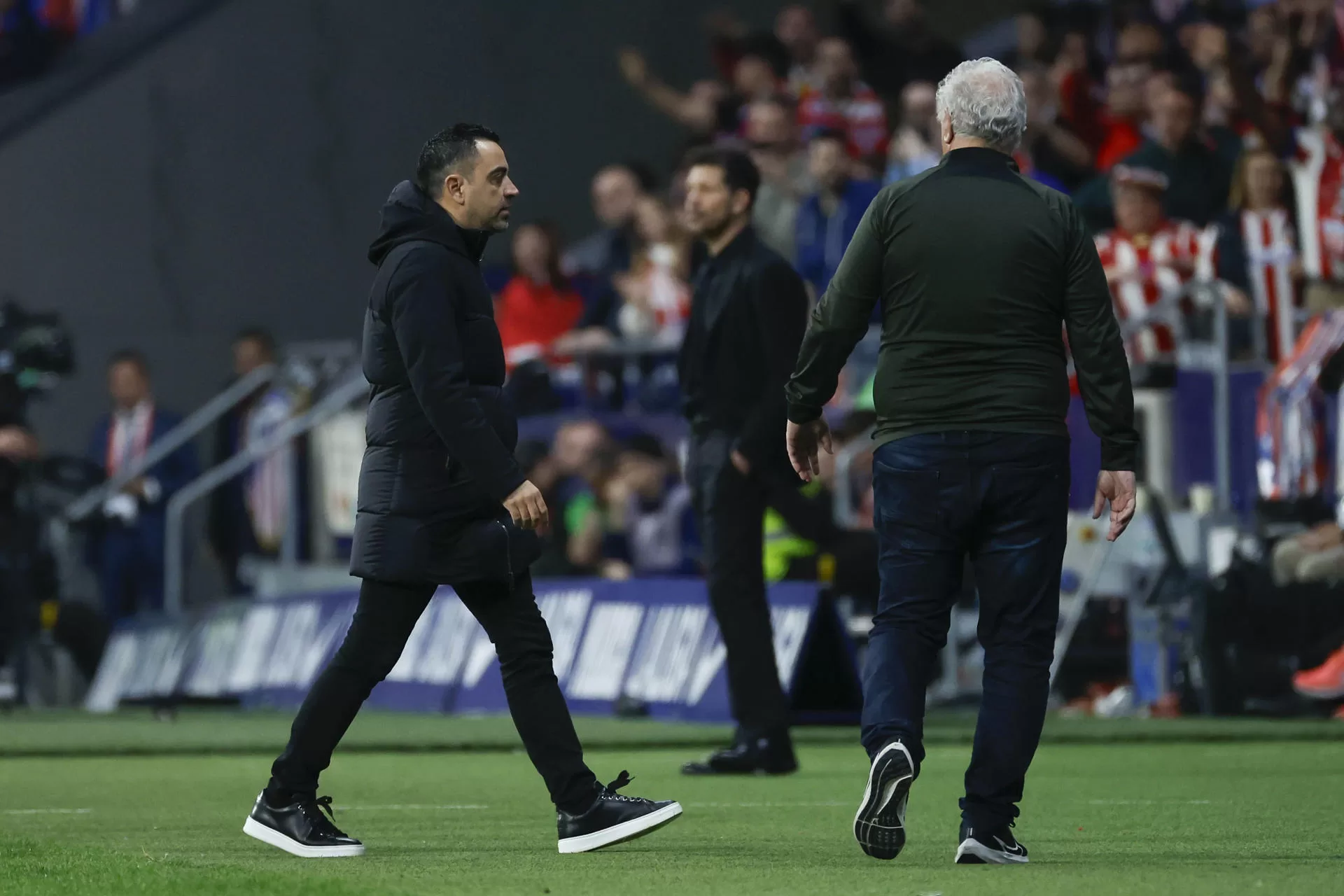El entrenador del Barcelona, Xavi Hernández (i), durante el partido de Liga en Primera División que Atlético de Madrid y FC Barcelona disputaron en el estadio Metropolitano. EFE/Juanjo Martín