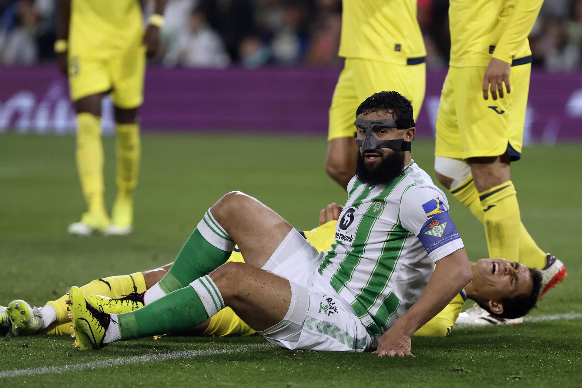 El centrocampista francés del Real Betis Nabil Fekir (i) cae junto al argelino Aissa Mandi, del Villarreal, durante el partido de la Jornada 28 de LaLiga EA Sports en el estadio Benito Villamarín. EFE/ Julio Muñoz 
