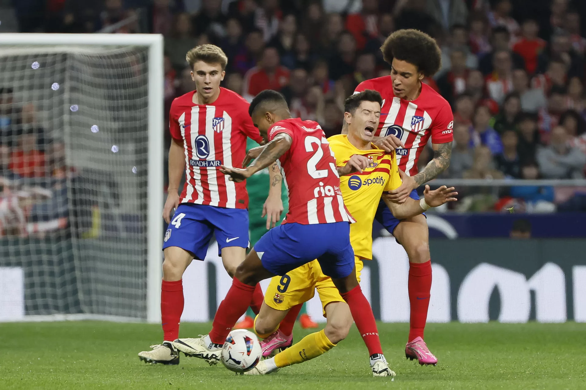 Robert Lewandowski (2d) del FC Barcelona cae ante varios rivales del Atlético de Madrid durante el partido de Liga en Primera División en el estadio Metropolitano. EFE/Ballesteros