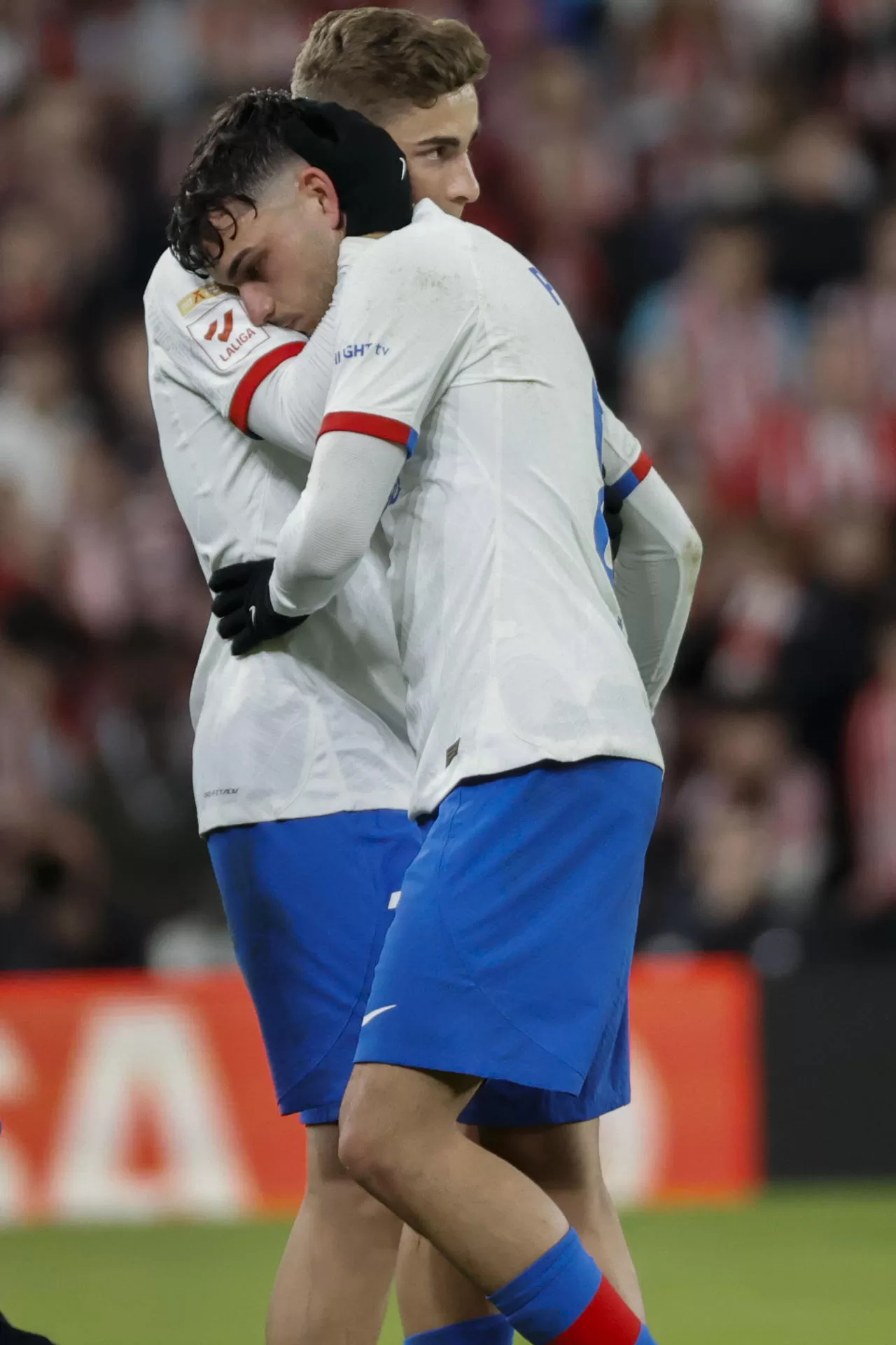 El centrocampista del FC Barcelona Pedri (d) es consolado por su compañero Fermín López tras lesionarse en el partido de Liga de Primera División en el estadio de San Mamés. EFE/Luis Tejido